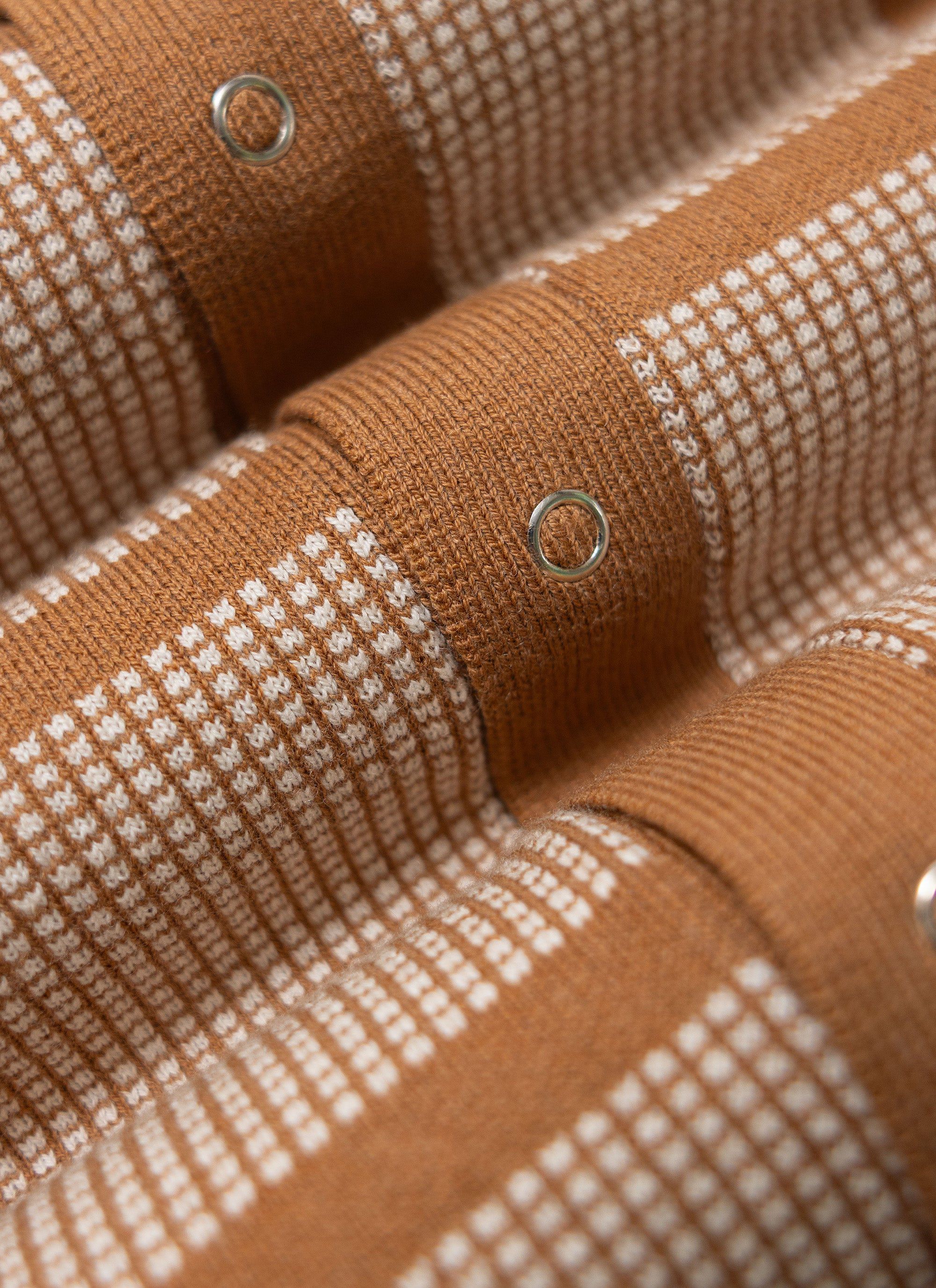 A close-up of the Percival Costa Knitted Shirt in tobacco, showing the retro square pattern and silver snap button detail.