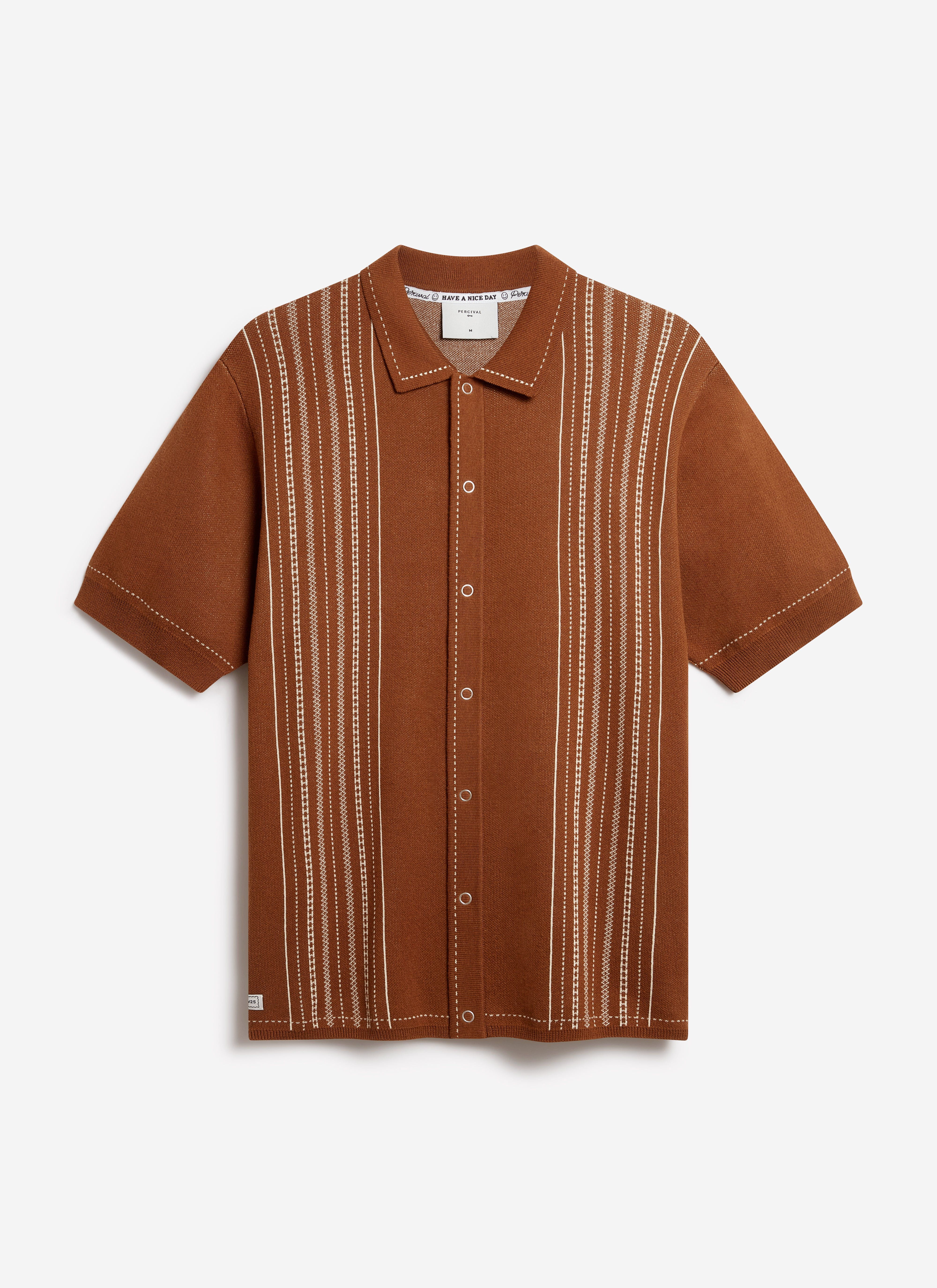 The Percival Accolades Knitted Shirt in tobacco brown, laid flat to showcase its vertical white book spine jacquard pattern.