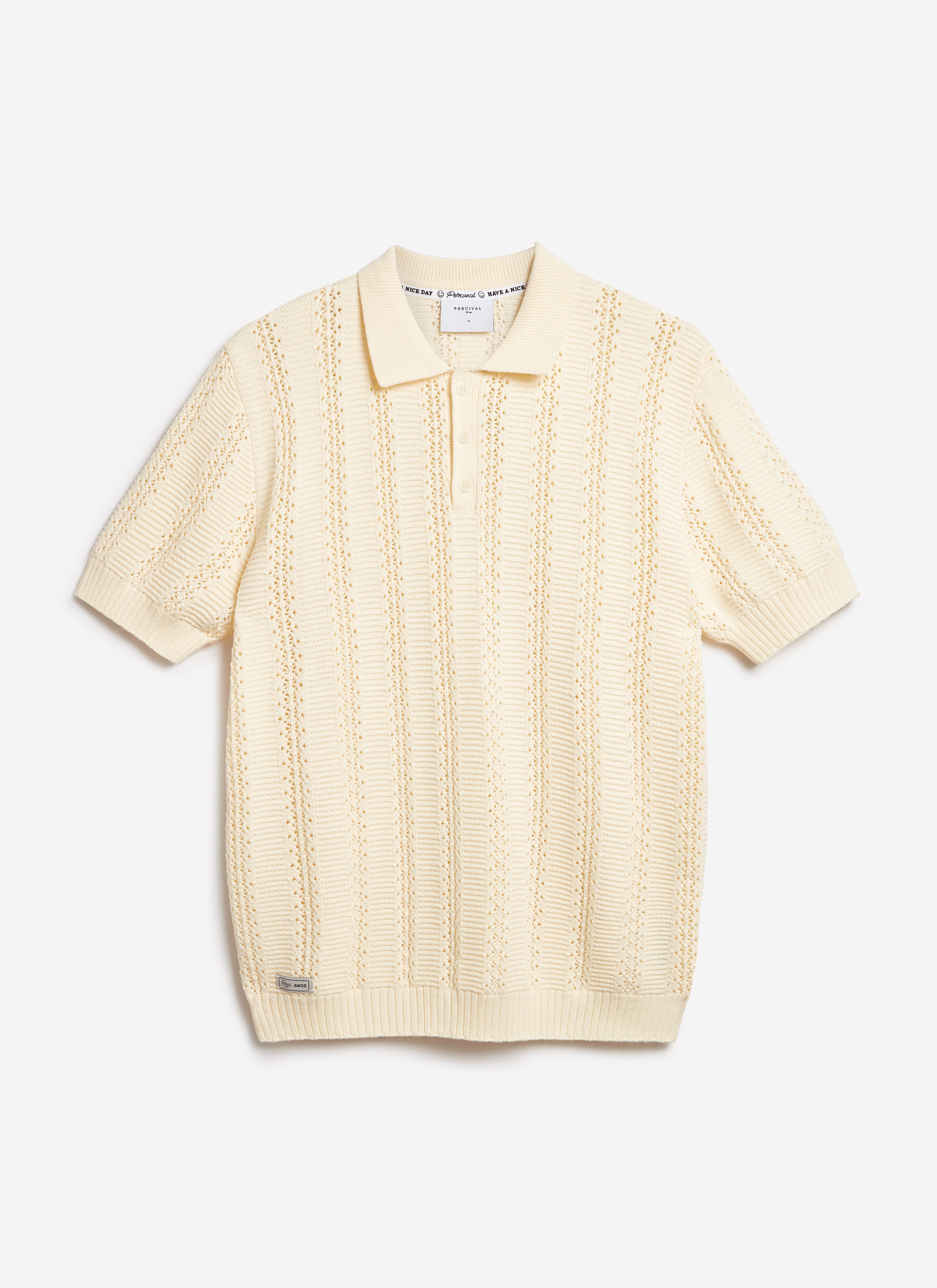 The Percival Addendum Knitted Polo Shirt in ecru cream cotton, laid flat to showcase the intricate textured knit.