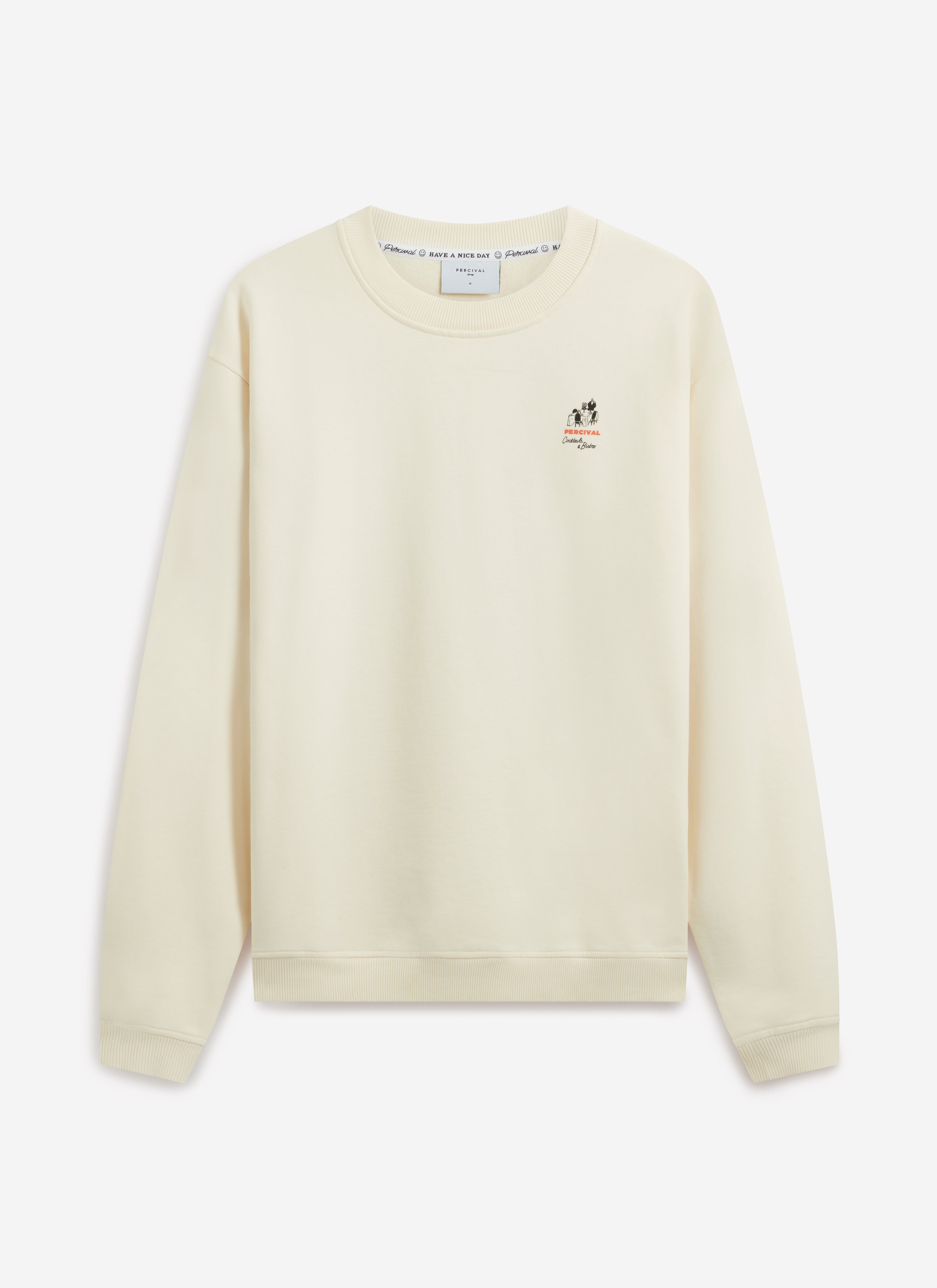 A model wears the Percival Bistro Printed Sweatshirt in ecru. Front-on studio shot showing the chest graphic and regular fit.