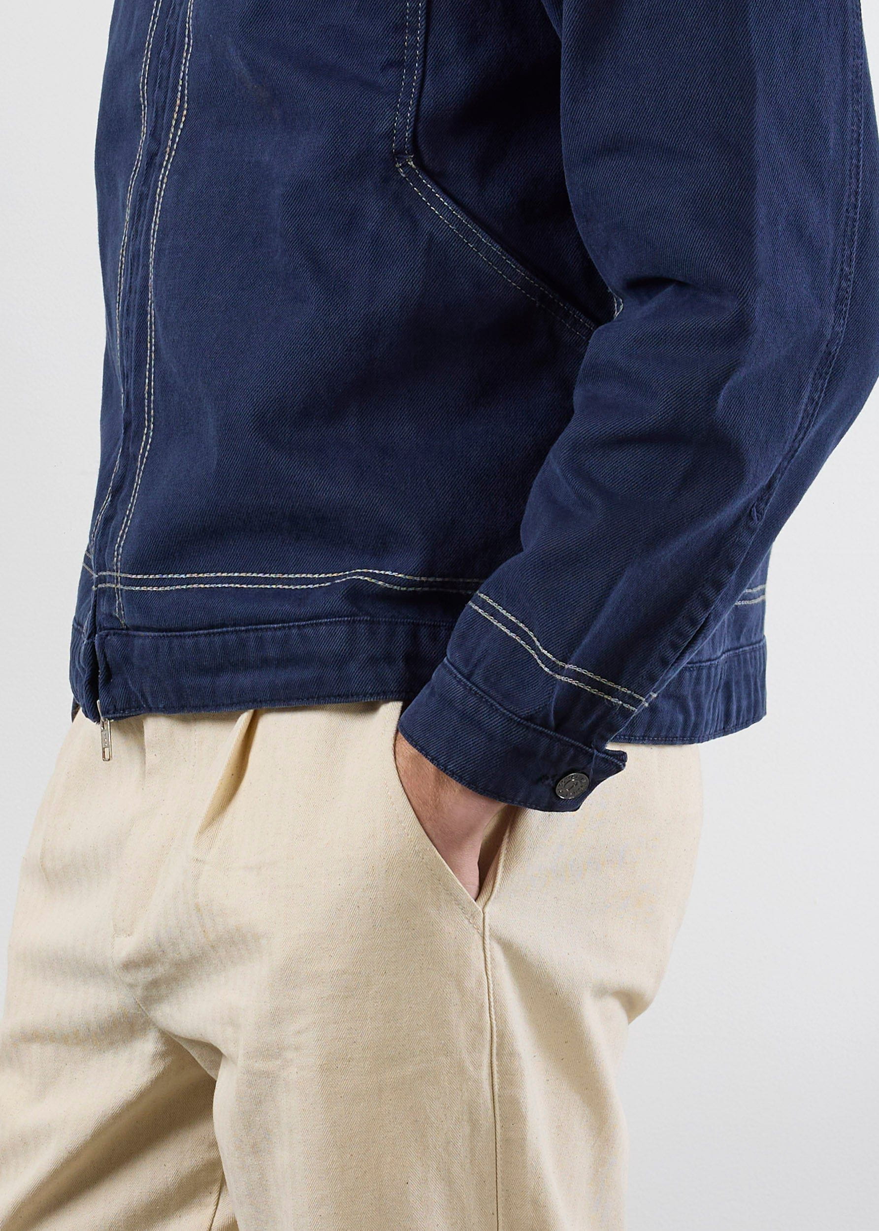 A side-view close-up of the Percival Calabria Harrington Jacket in navy, showing the contrast stitching and cotton texture.