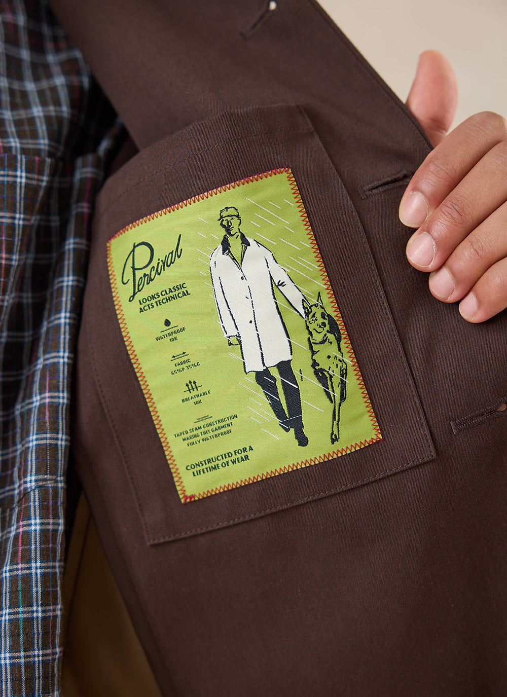 A close-up of the interior label on the espresso Percival Carter Jacket detailing its waterproof features.