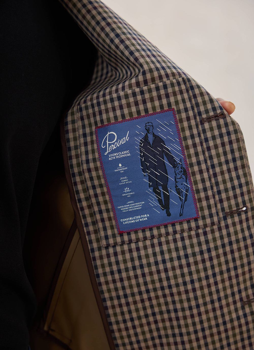 A close-up of the interior label and Watcher Check lining inside the waterproof Carter Cropped Jacket from Percival.