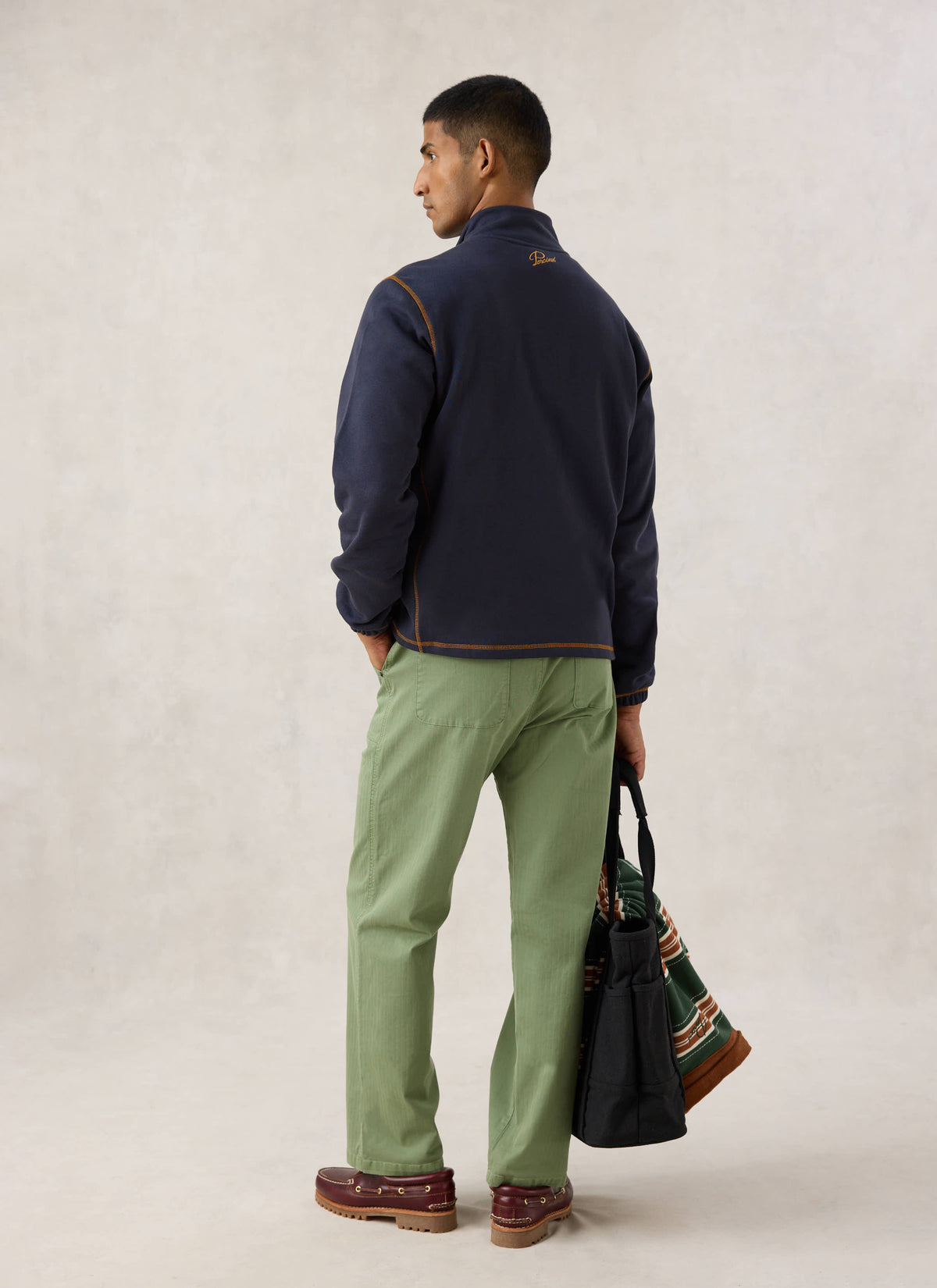 Rear view of a model wearing the navy Curtis sweatshirt from Guinness x Percival, showing back neck embroidery.