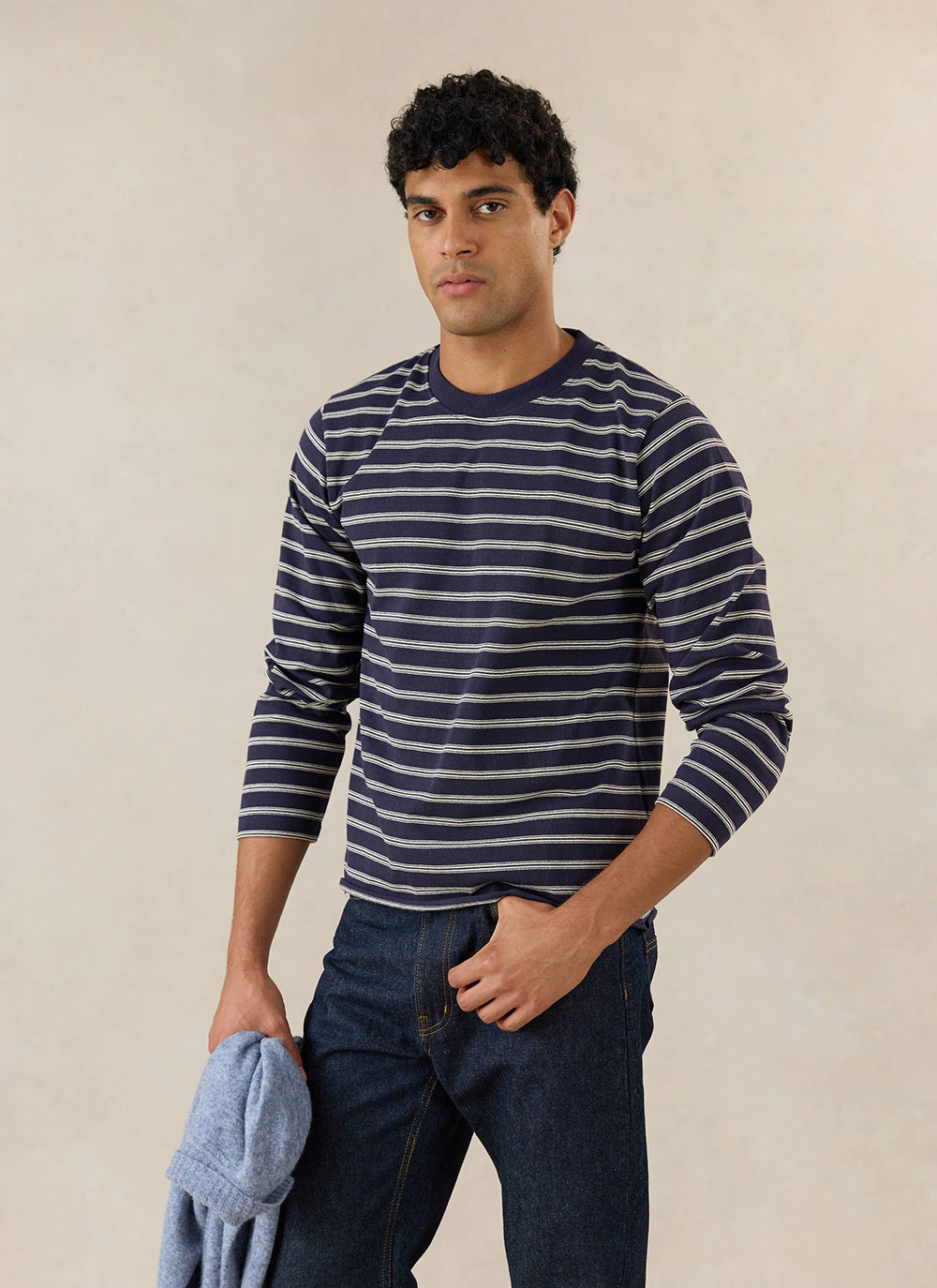 A model wears the navy stripe Percival Arlo long sleeve Breton T-shirt, styled with blue jeans.