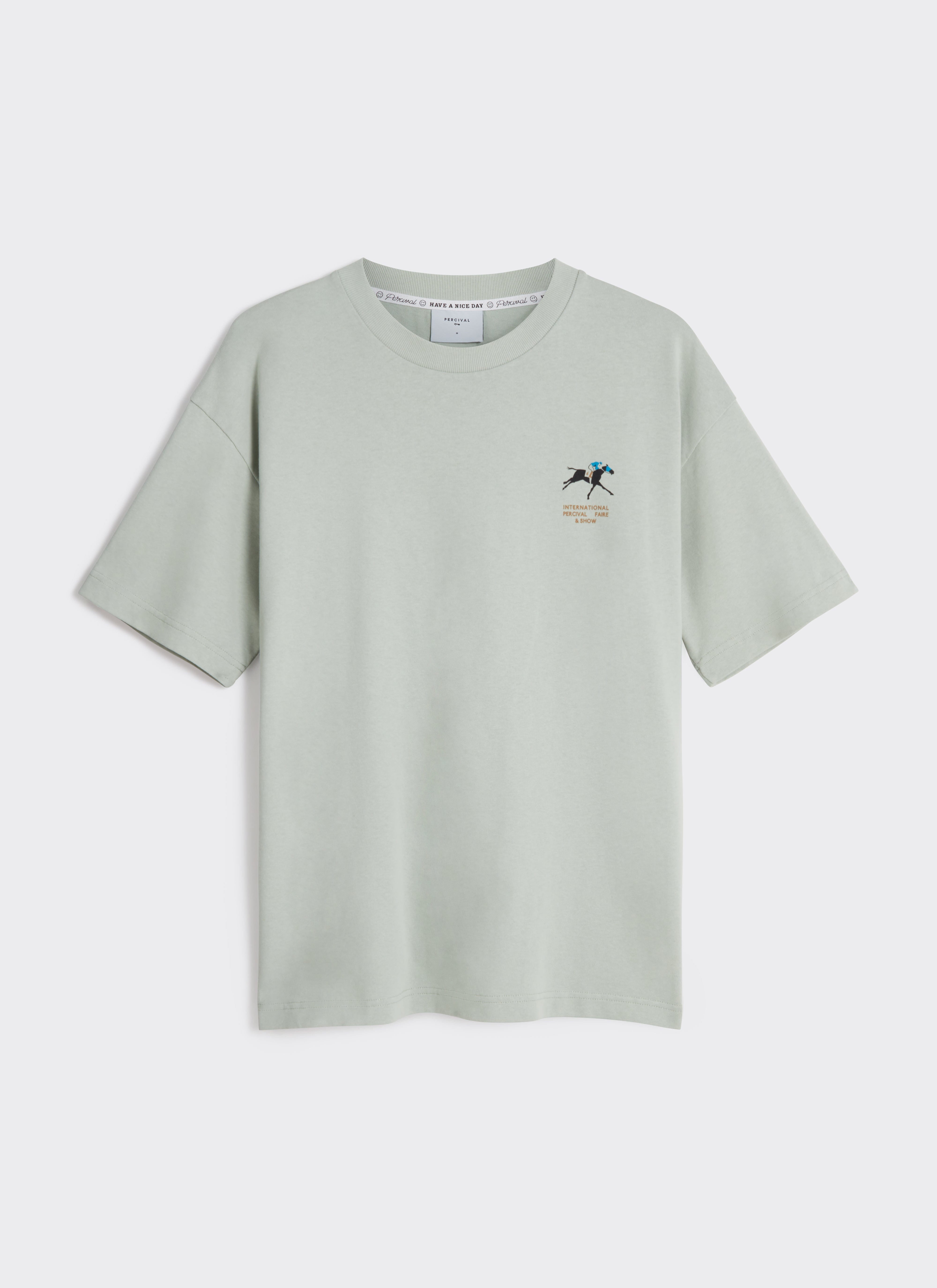 A flat lay of the Percival Fair and Show Oversized T Shirt in sage green, featuring the horse and jockey chest graphic.