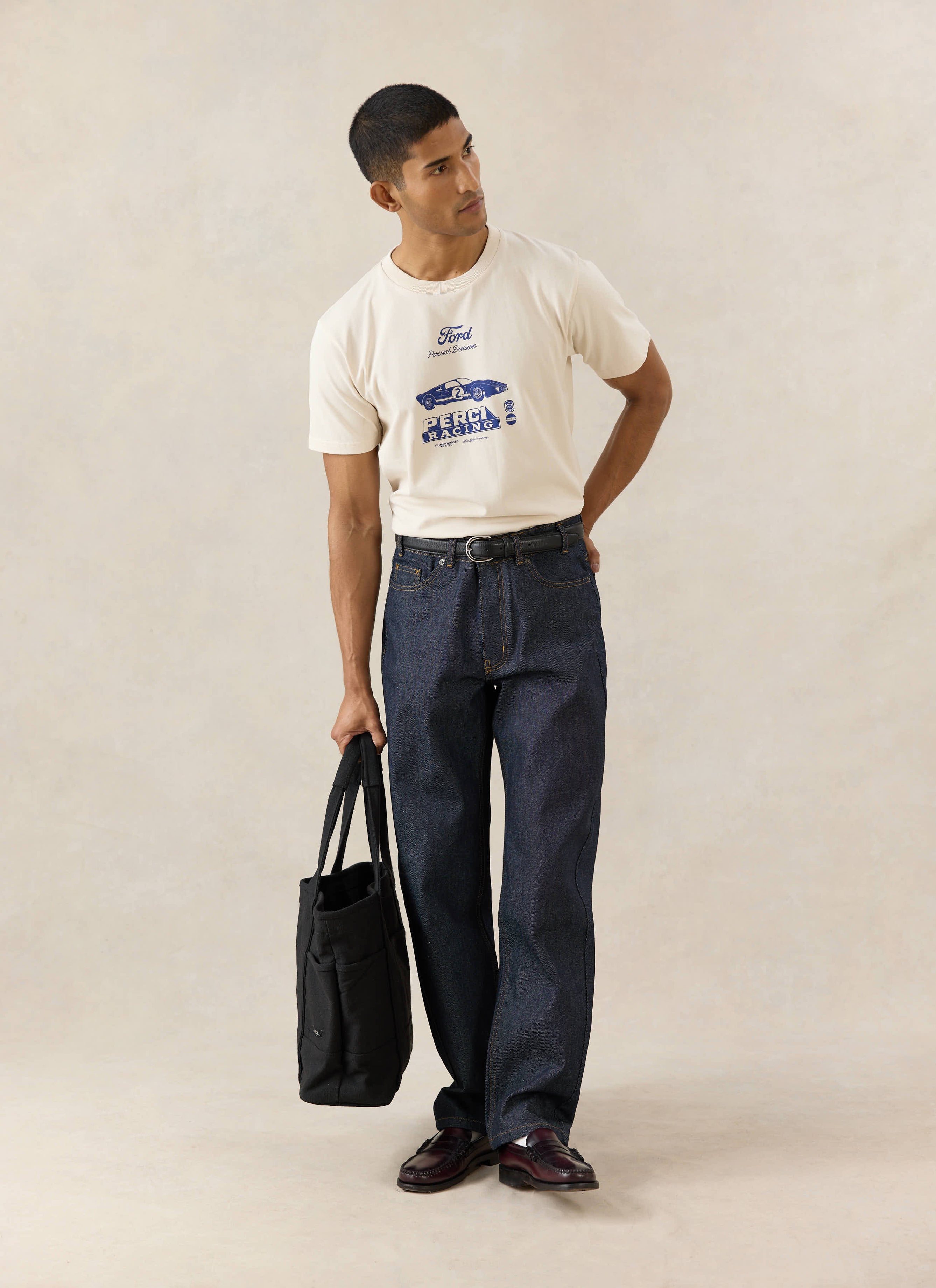 Cream Percival x Ford GT40 archive t-shirt styled with raw straight leg heritage denim jeans and a black canvas tote.