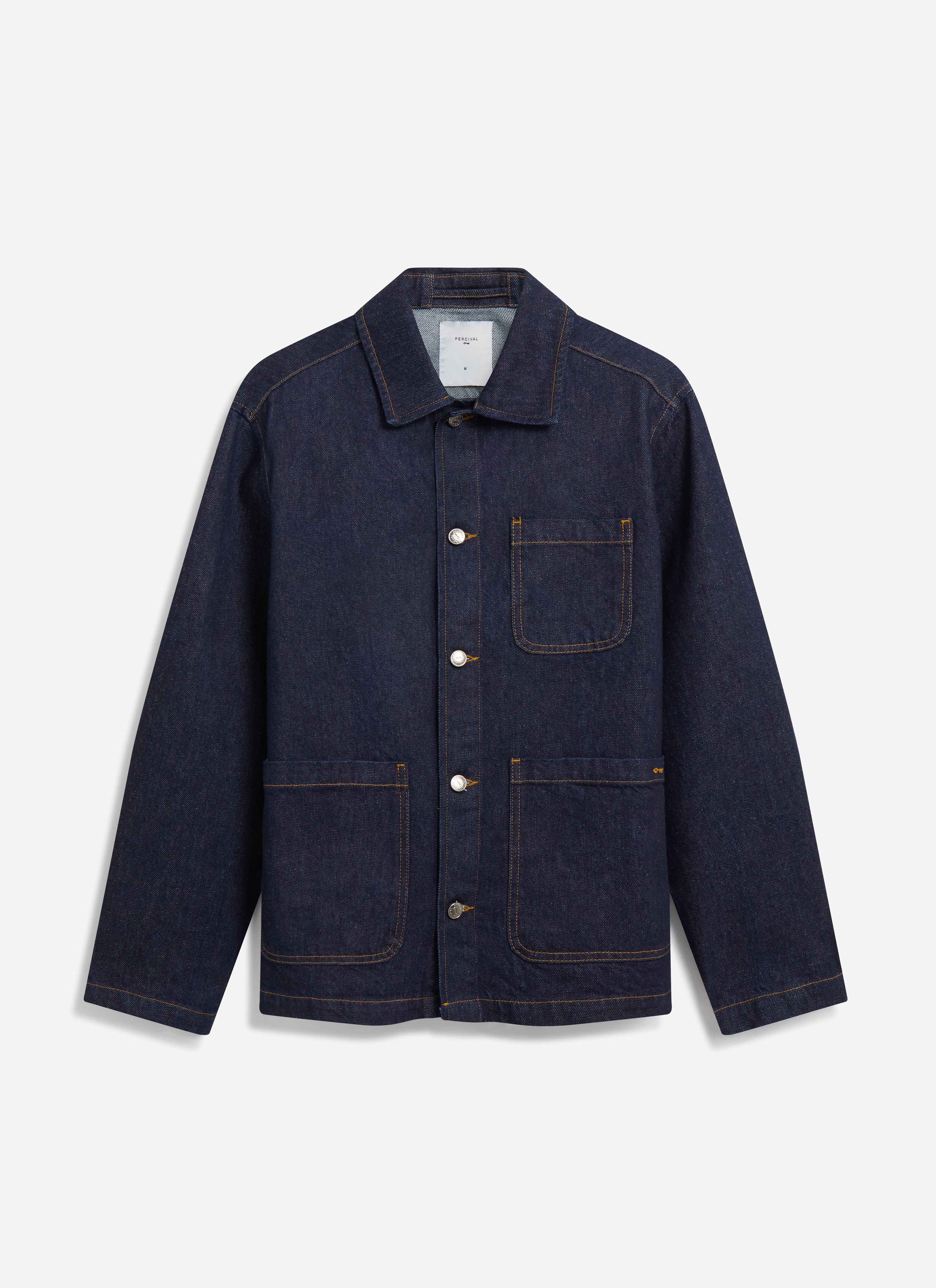 The Percival Gove Chore Jacket in dark indigo denim, laid flat to show its classic cut, patch pockets and contrast stitching.