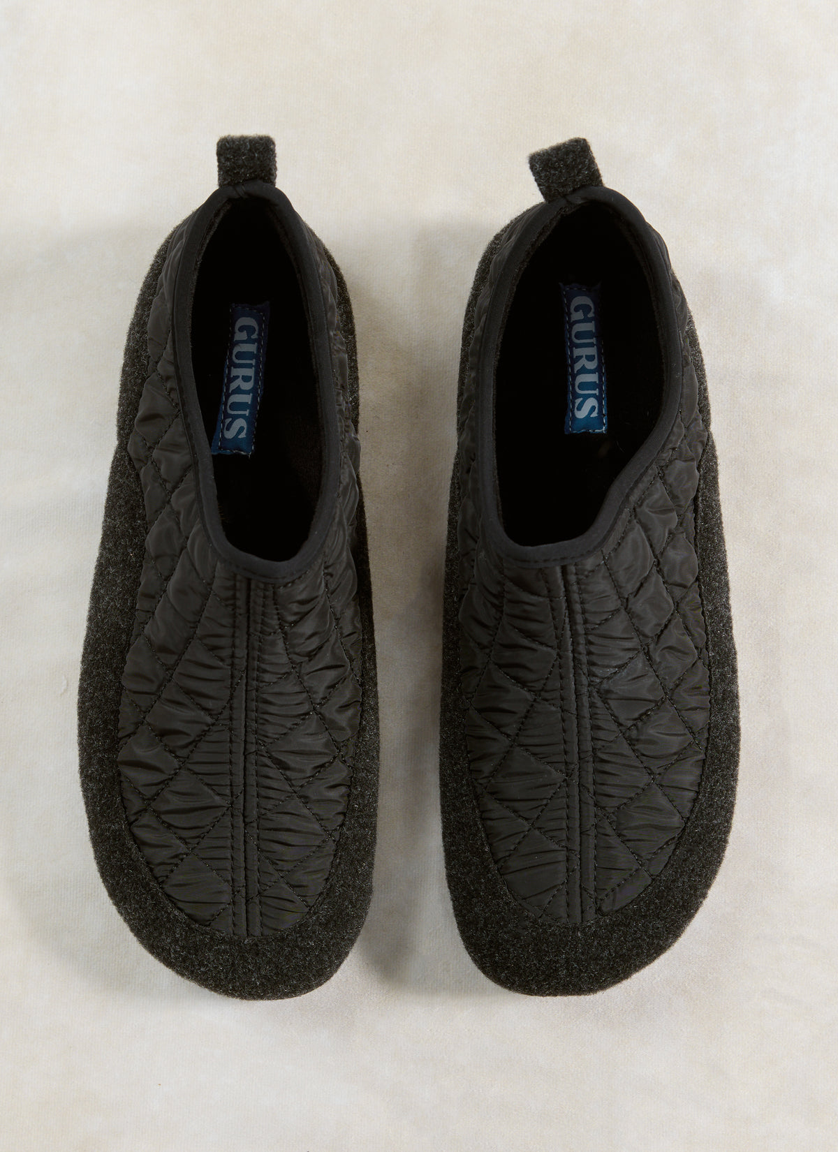 A top-down view of the Percival Gurus Valencia Classic Homeshoe in black, showing the quilted nylon upper and felt foxing.