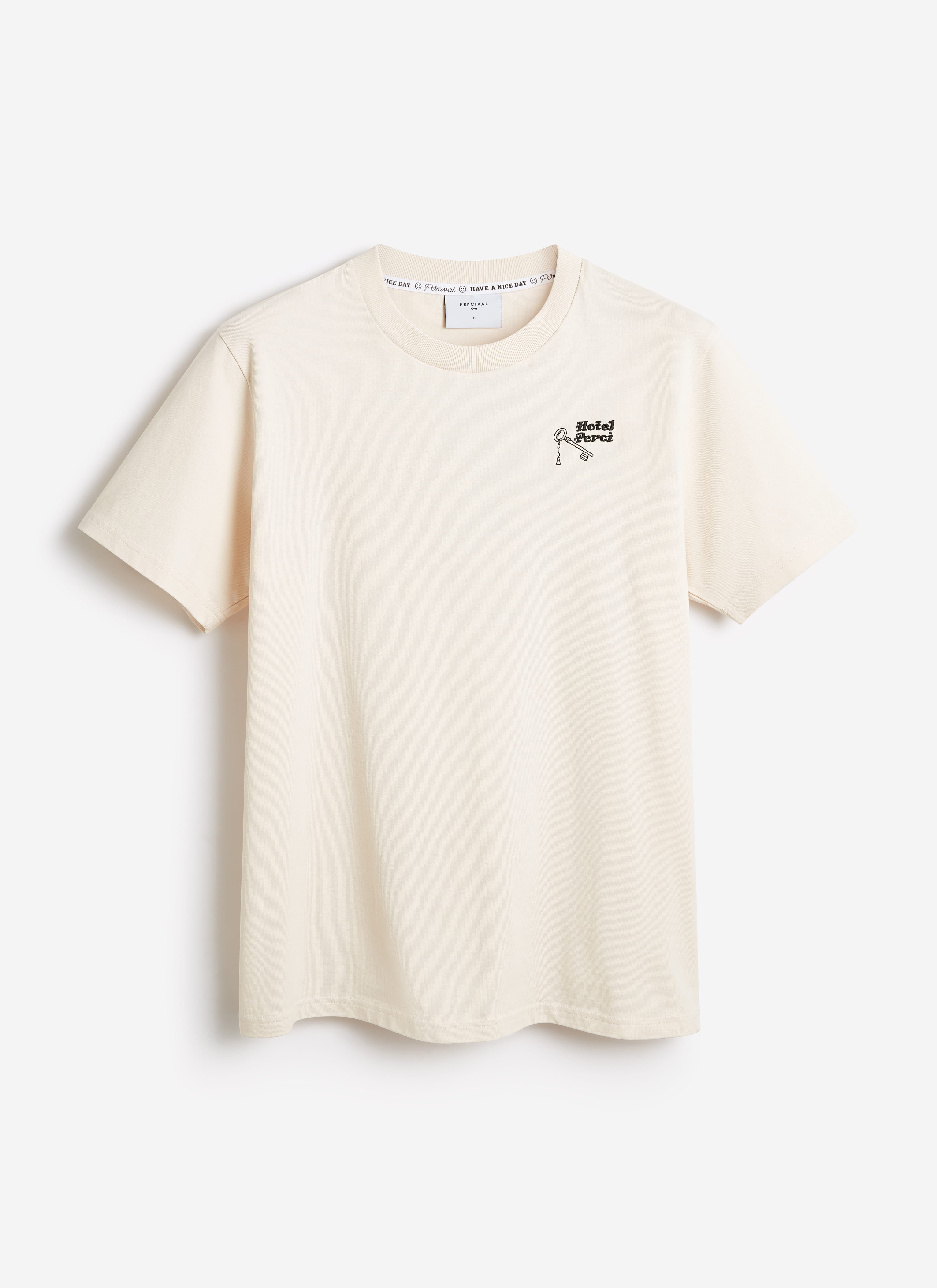 Percival Hotel T-shirt in ecru organic cotton, featuring a small 'Hotel Perci' key graphic on the chest.