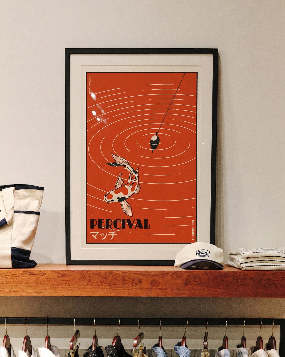 The framed Percival Koi Fish Giclée fine art print displayed on a wooden shelf in store.