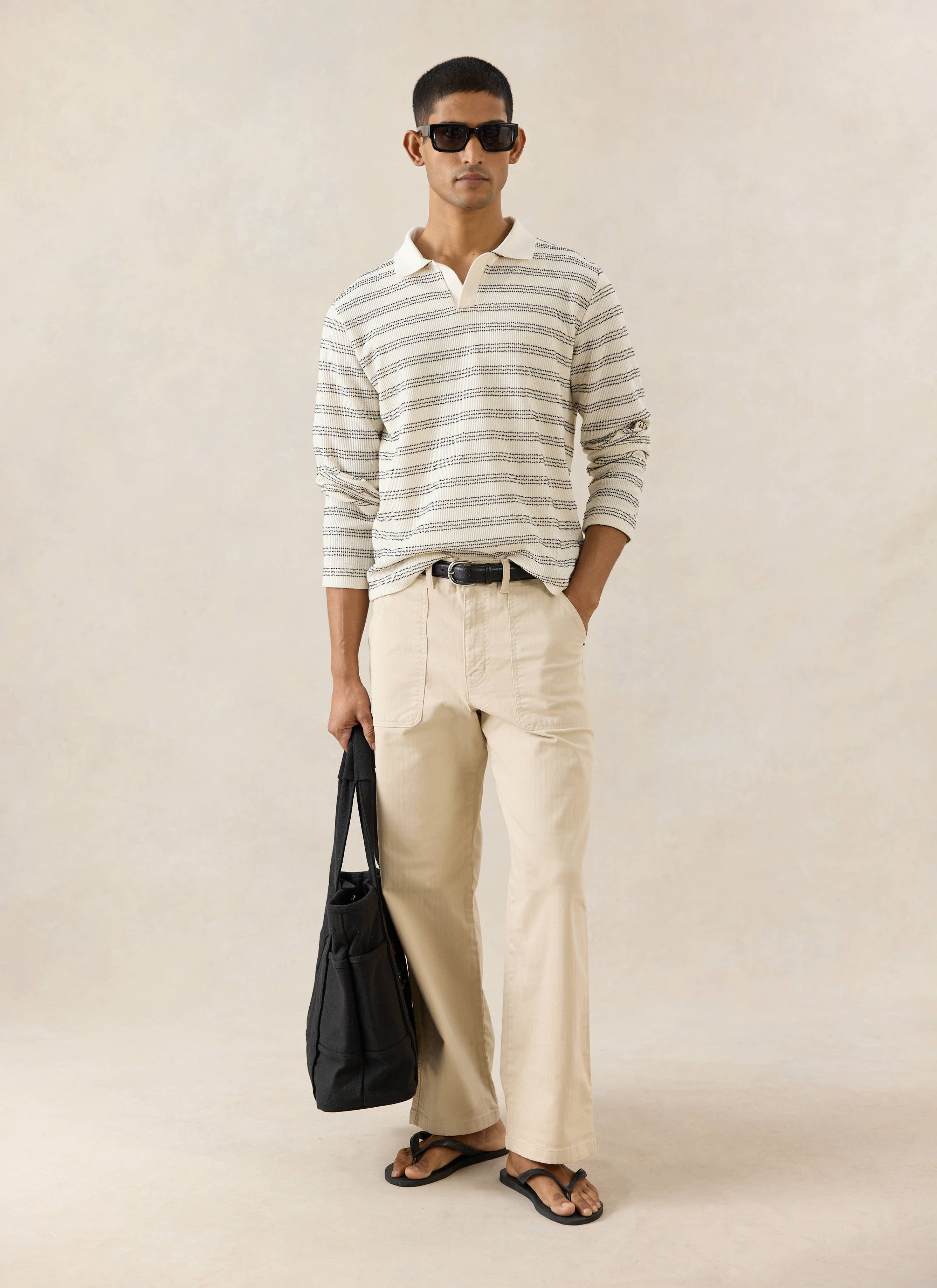 Percival Laurent long sleeve striped polo in cream cotton blend, styled with Lucas carpenter trousers and a black tote bag.