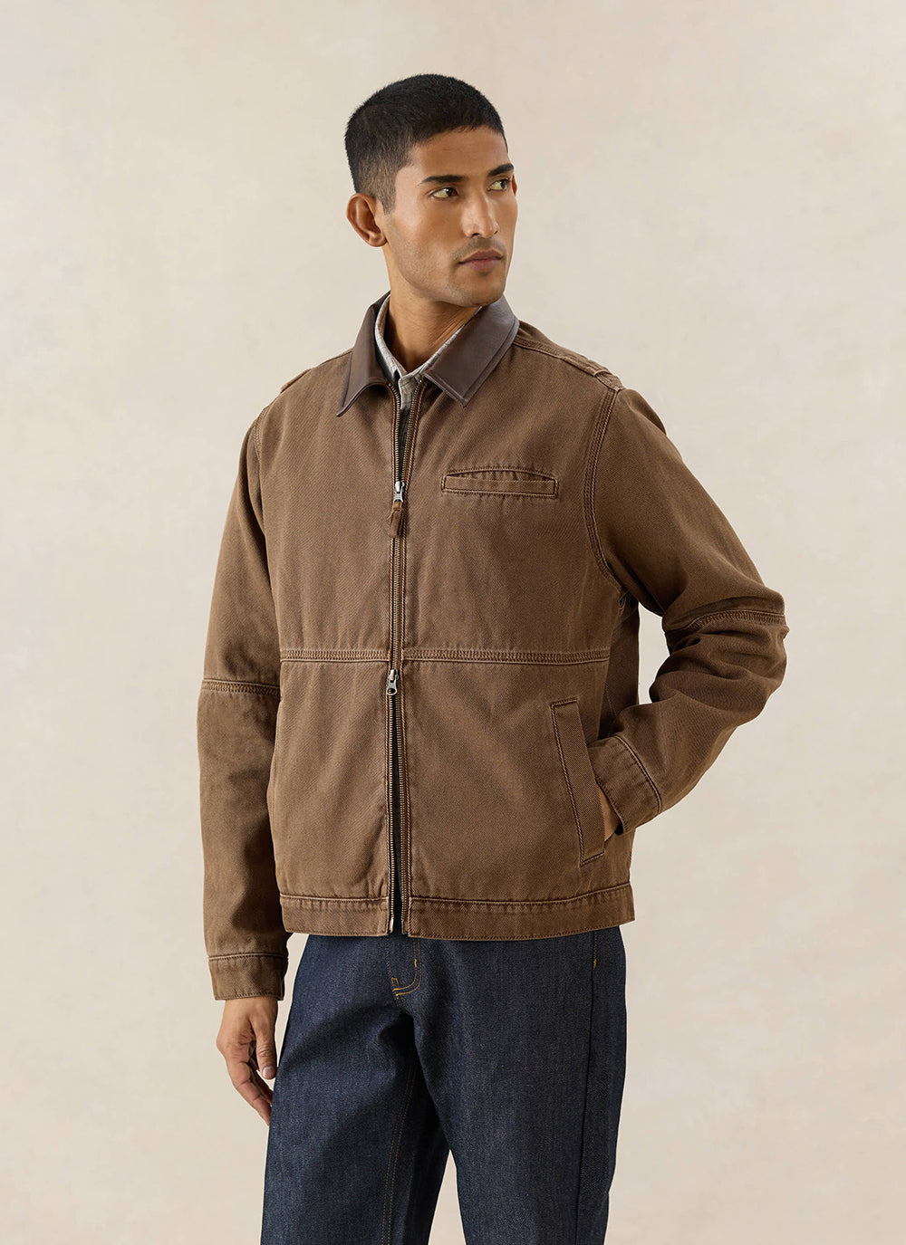 A model wears the Percival Lucas Vintage Wash Contrast Collar Jacket in mocha brown cotton twill with dark denim jeans.