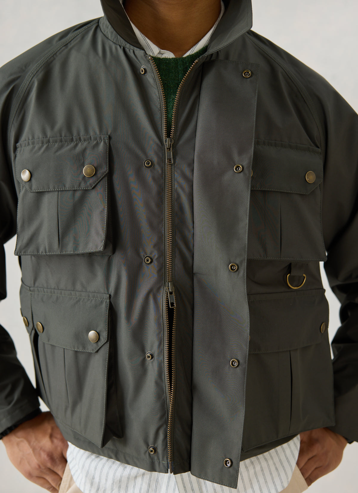 Close-up of the Percival forest green Hunter Field Jacket showing the front pockets, zipper, and popper-fastened placket.
