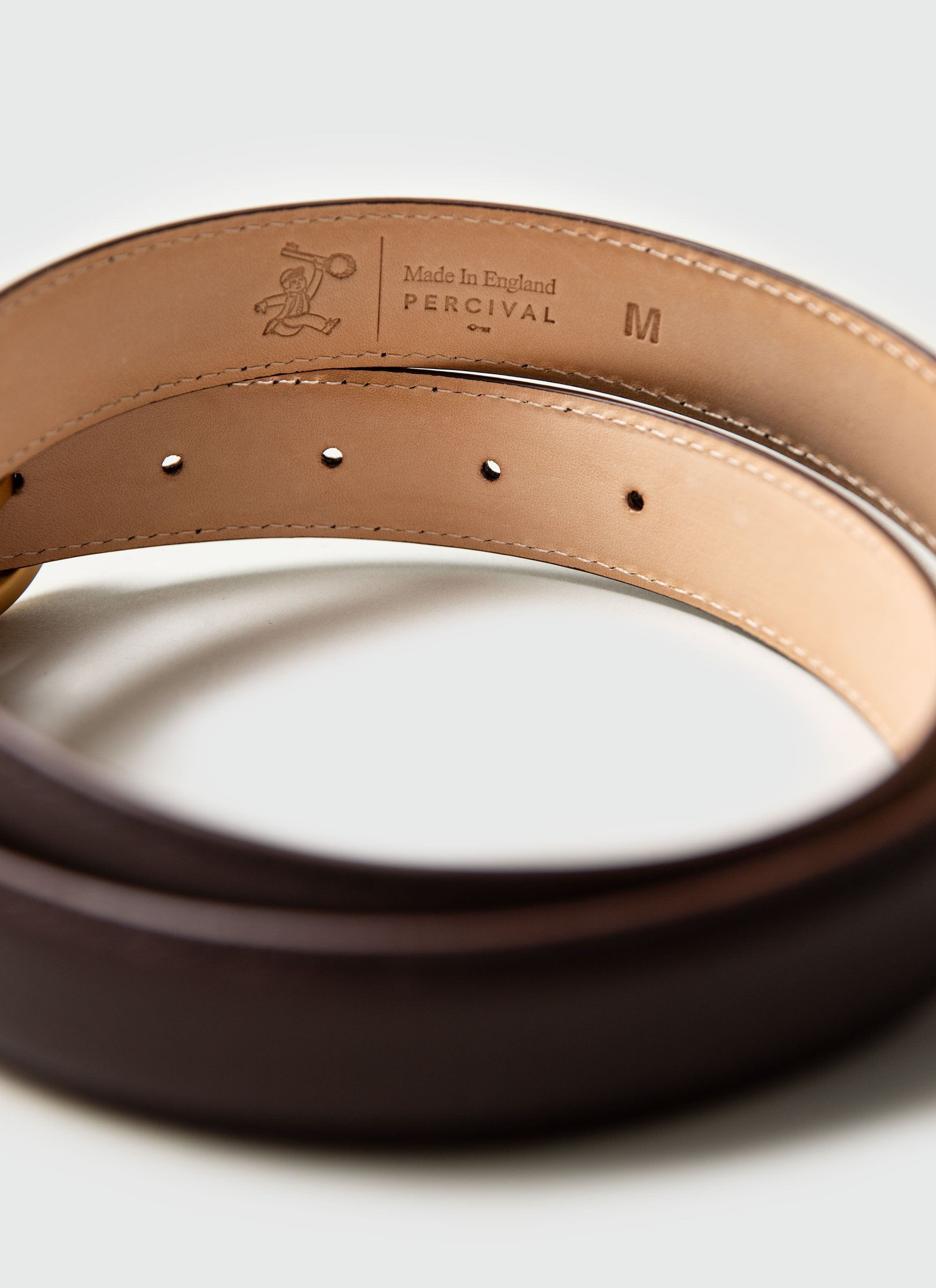 A close-up of the interior of the brown leather dress belt, showing the debossed Percival and 'Made in England' stamps.
