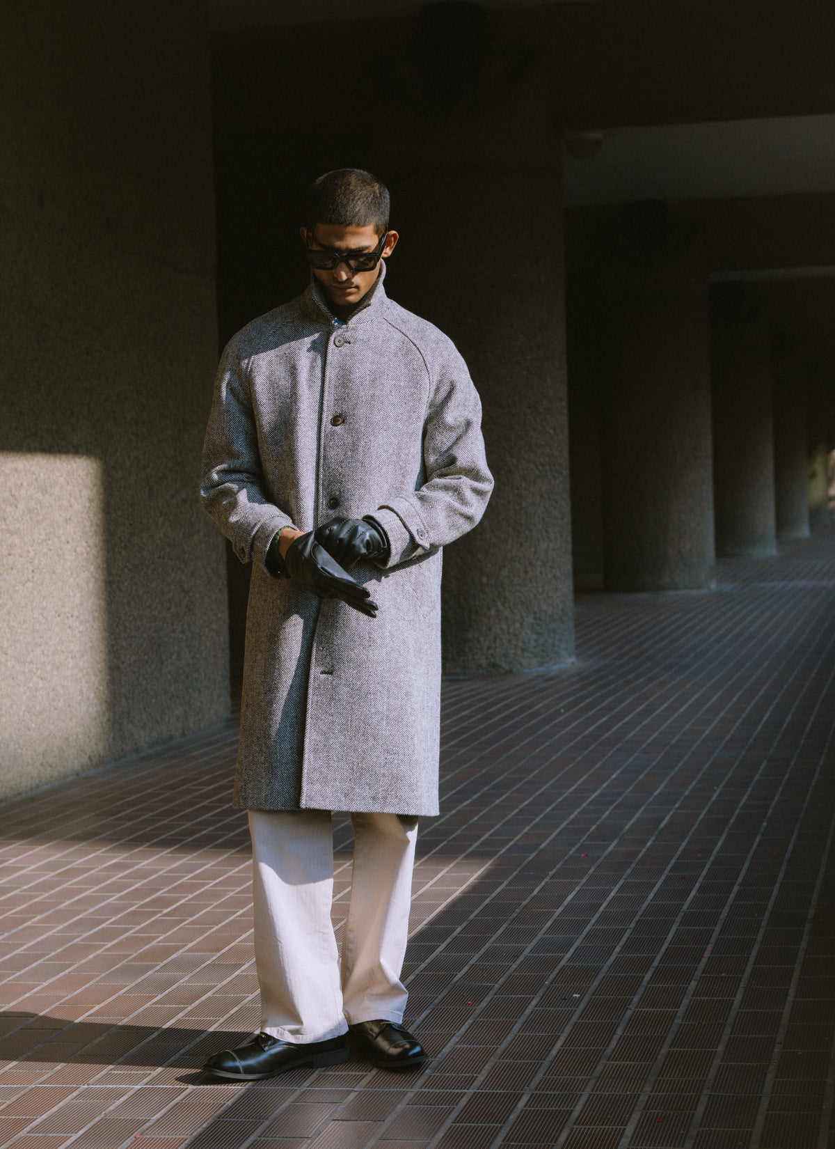 A model wearing the grey herringbone Wool Car Coat by Percival, featuring a button-through front.