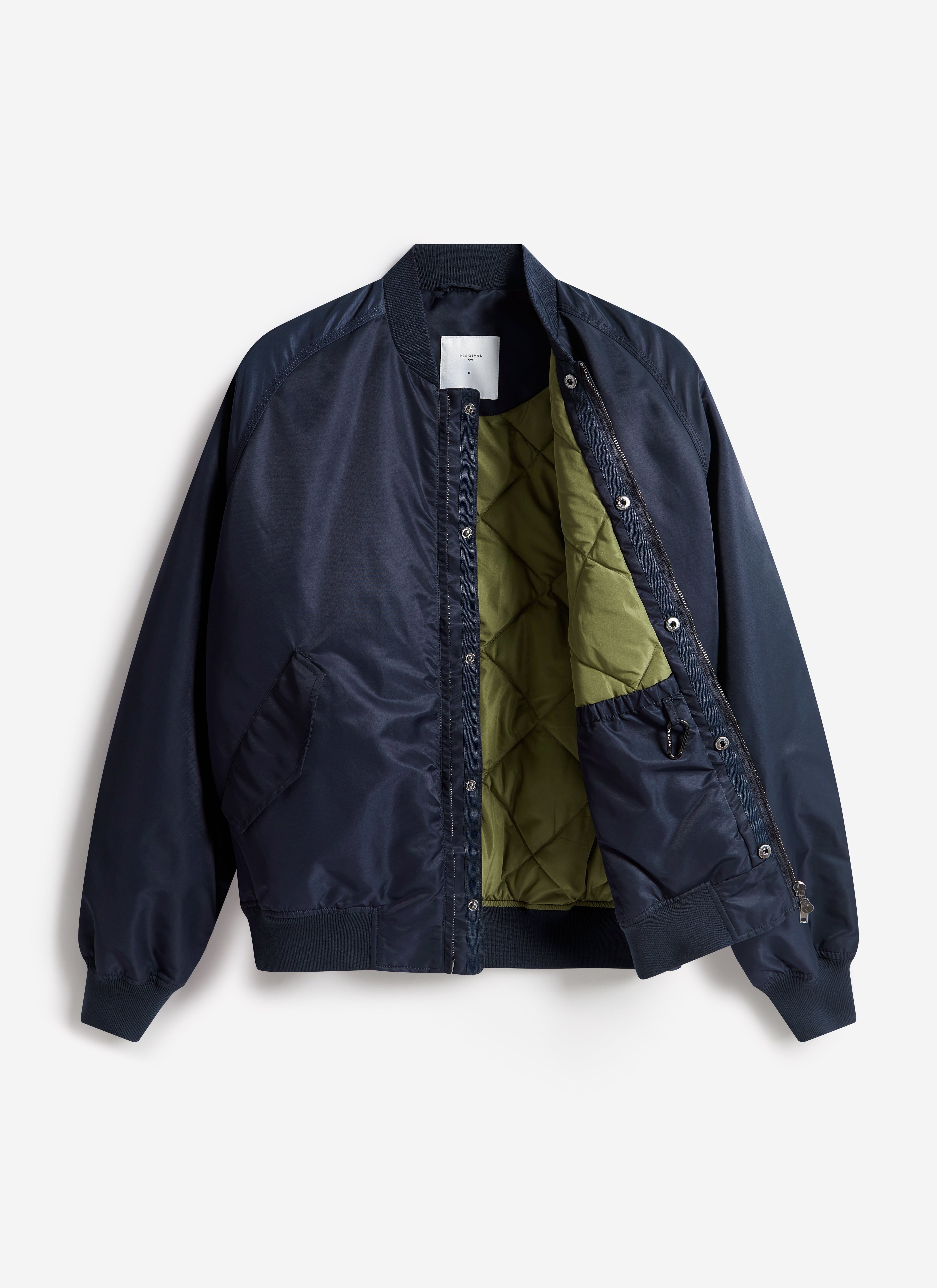 A Percival men's bomber jacket in midnight navy nylon, open to reveal the contrasting olive green quilted interior.