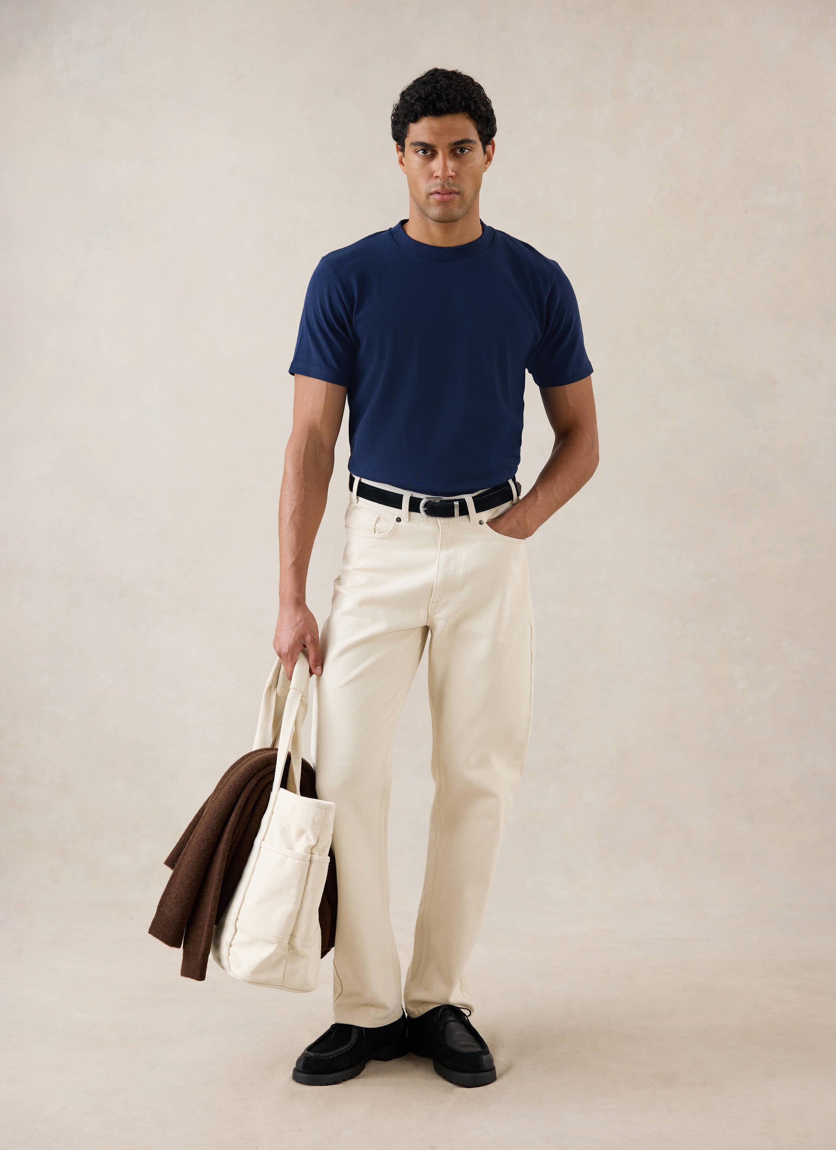 Model wearing Percival's Plain Regular T Shirt in Navy with Percival Cream Jeans.