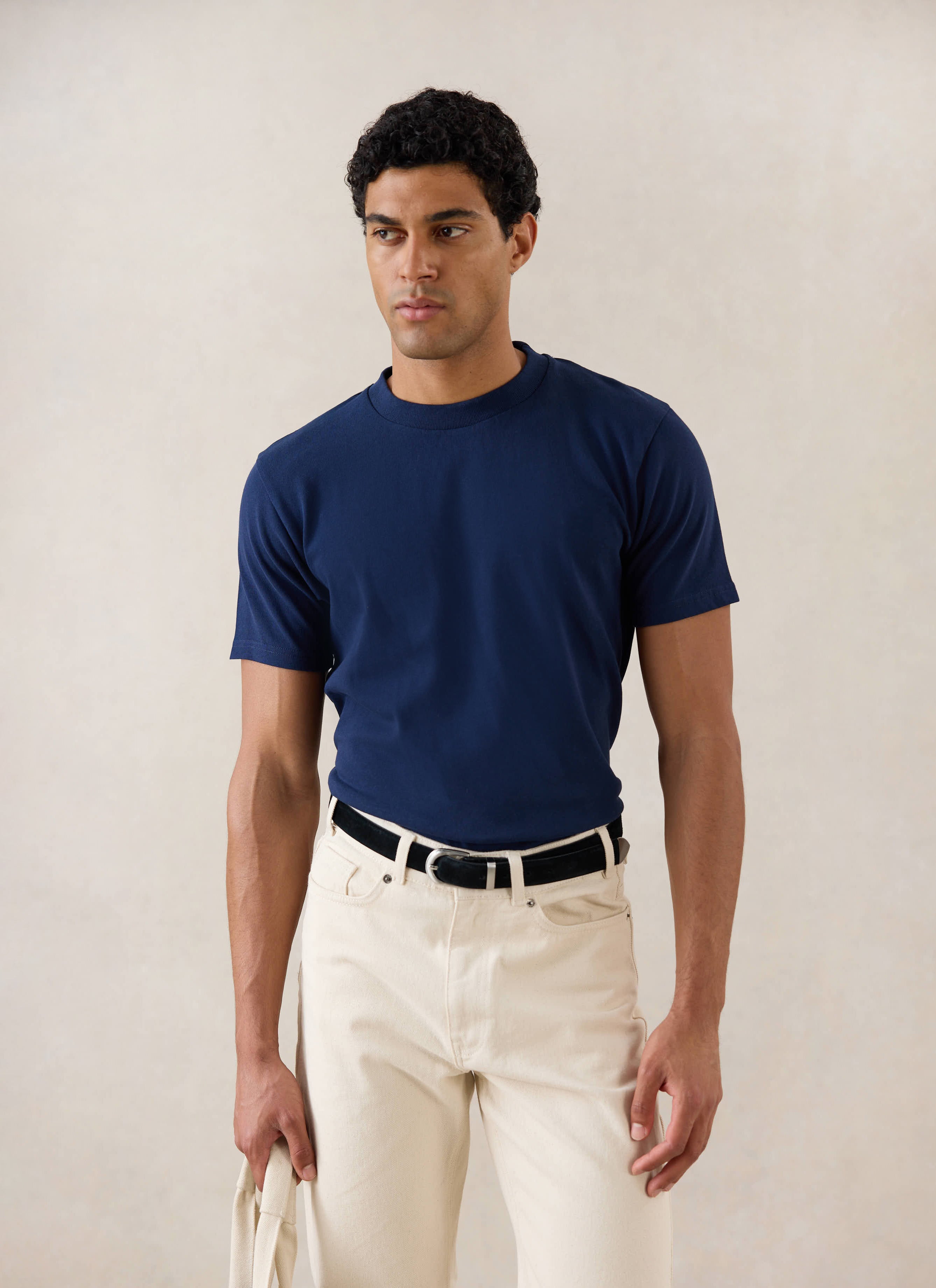 Model wearing Percival's Plain Regular T Shirt in Navy with Percival Cream Jeans.
