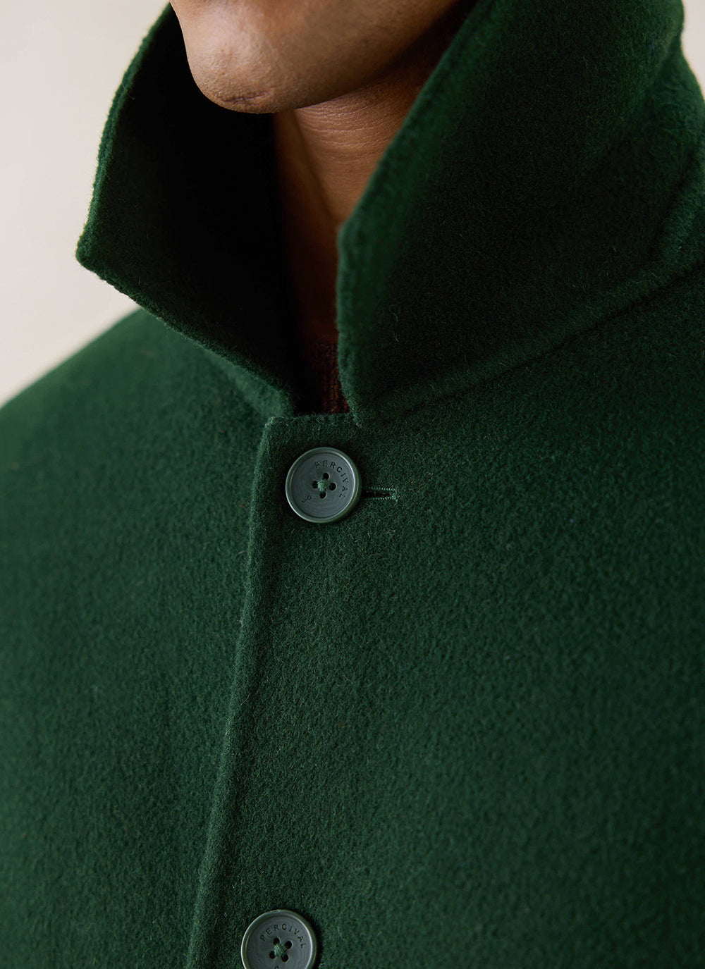 A close-up of the forest green wool Minnesota Overcoat from Percival, showing the collar and buttons.