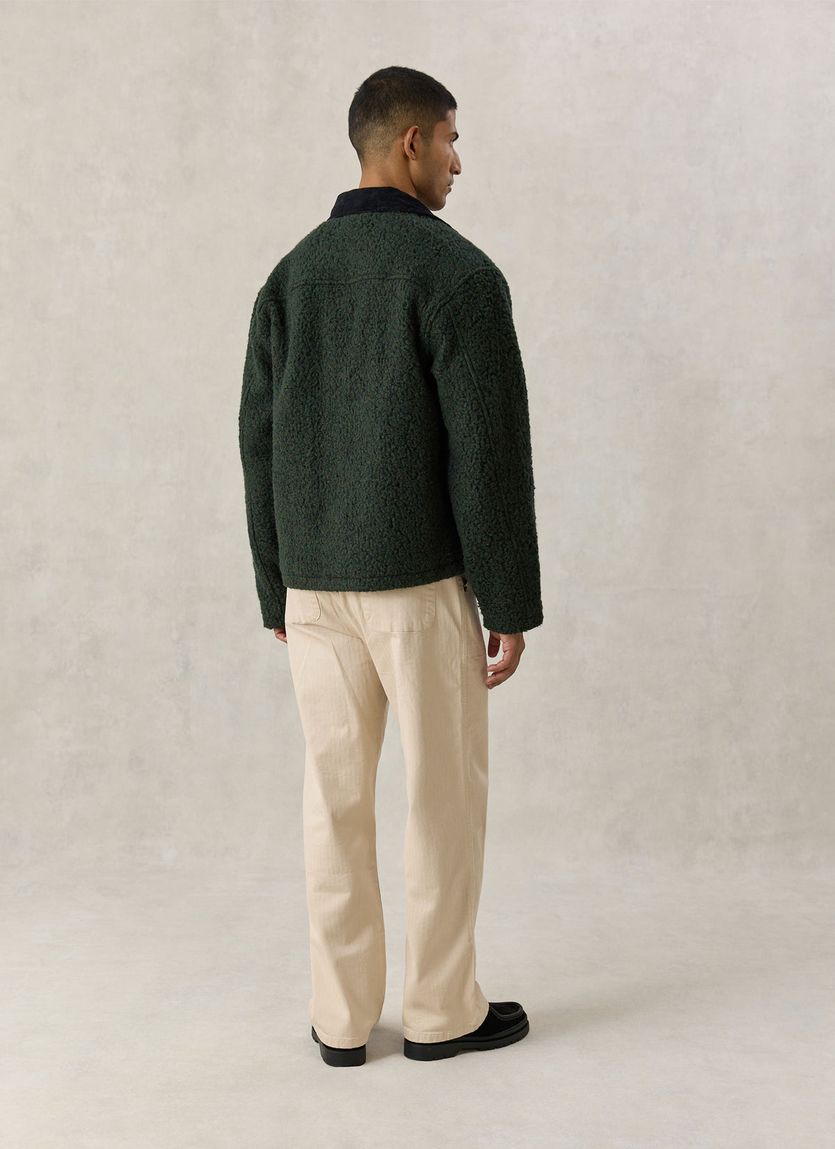 A model wearing the Percival forest green wool-blend fleece jacket from the back, showing the texture and cord collar.