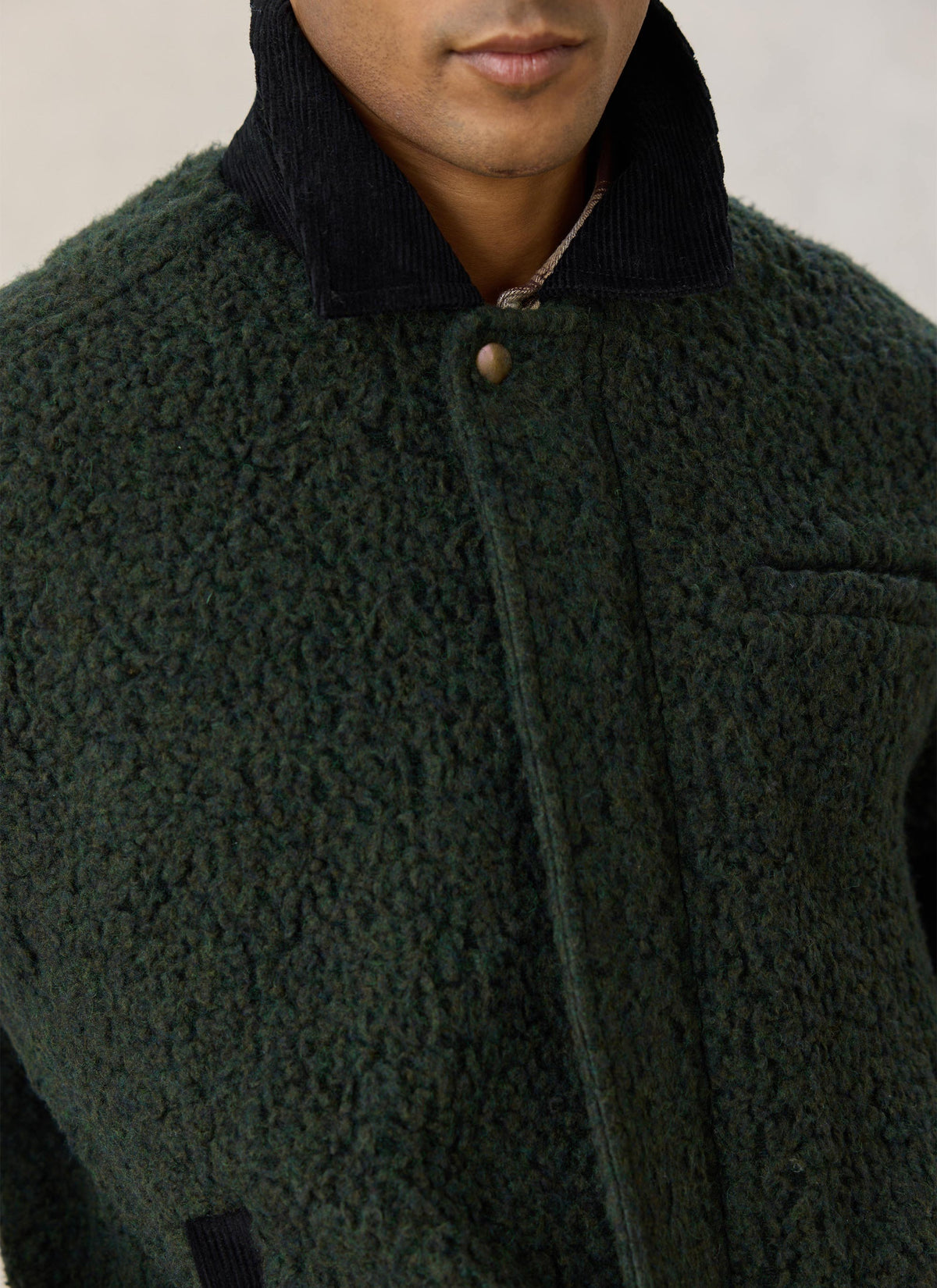 Close-up of the Percival green fleece jacket, highlighting the textured fabric and dark cord collar.