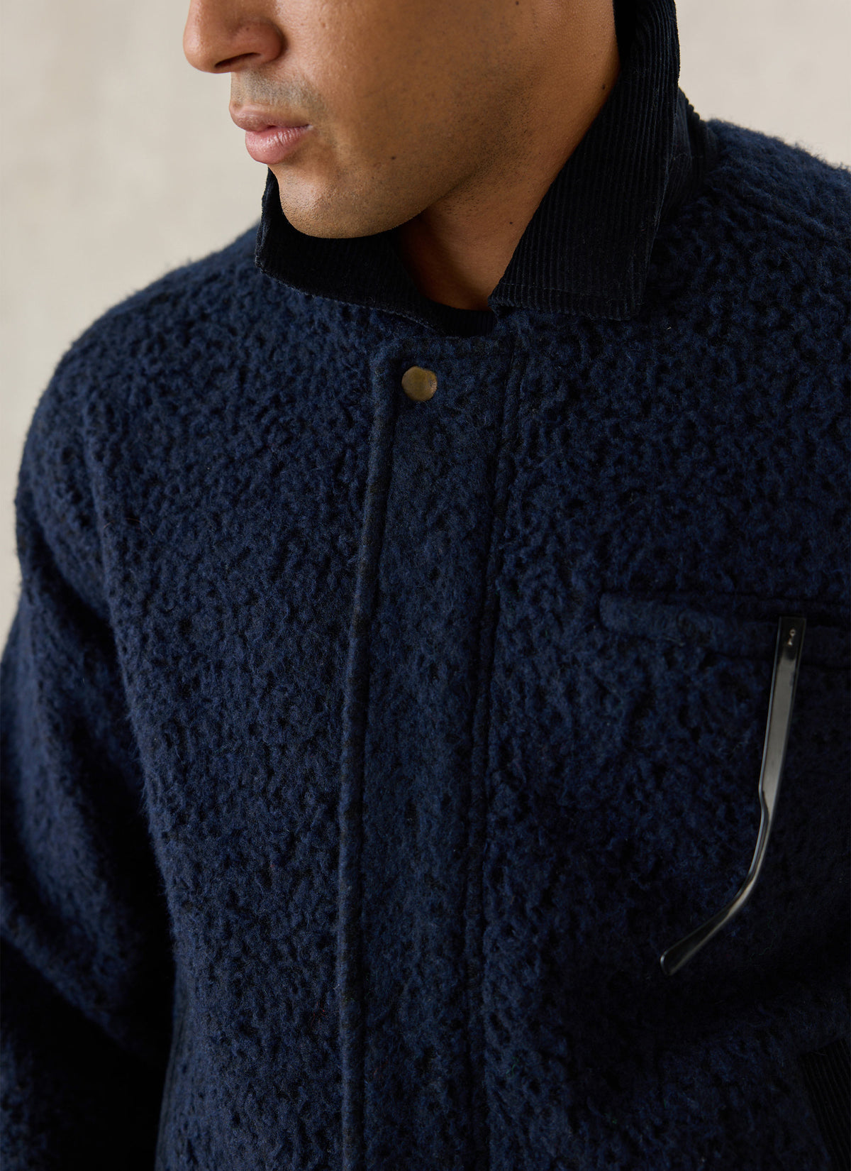 Close-up of a model wearing the navy Percival Murrey fleece jacket, showing the corduroy collar and textured wool blend.