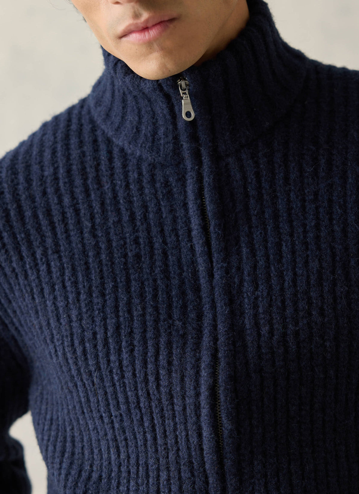 Close-up of the Percival navy Norton zip cardigan, showing the chunky alpaca-wool blend and high collar.