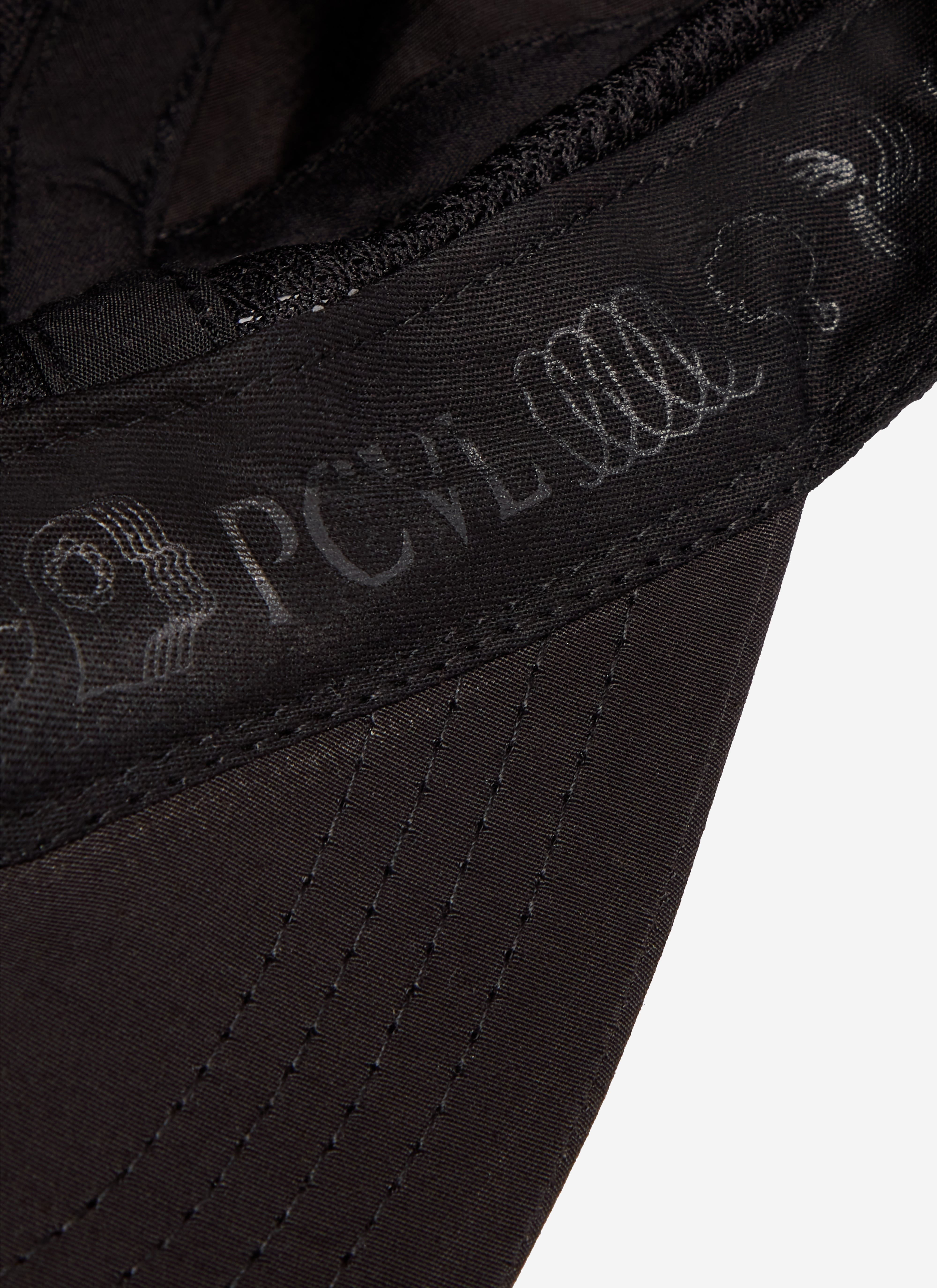 Close-up of the Percival PCVL Nylon Cap in black, highlighting the tonal branding on the interior sweatband.