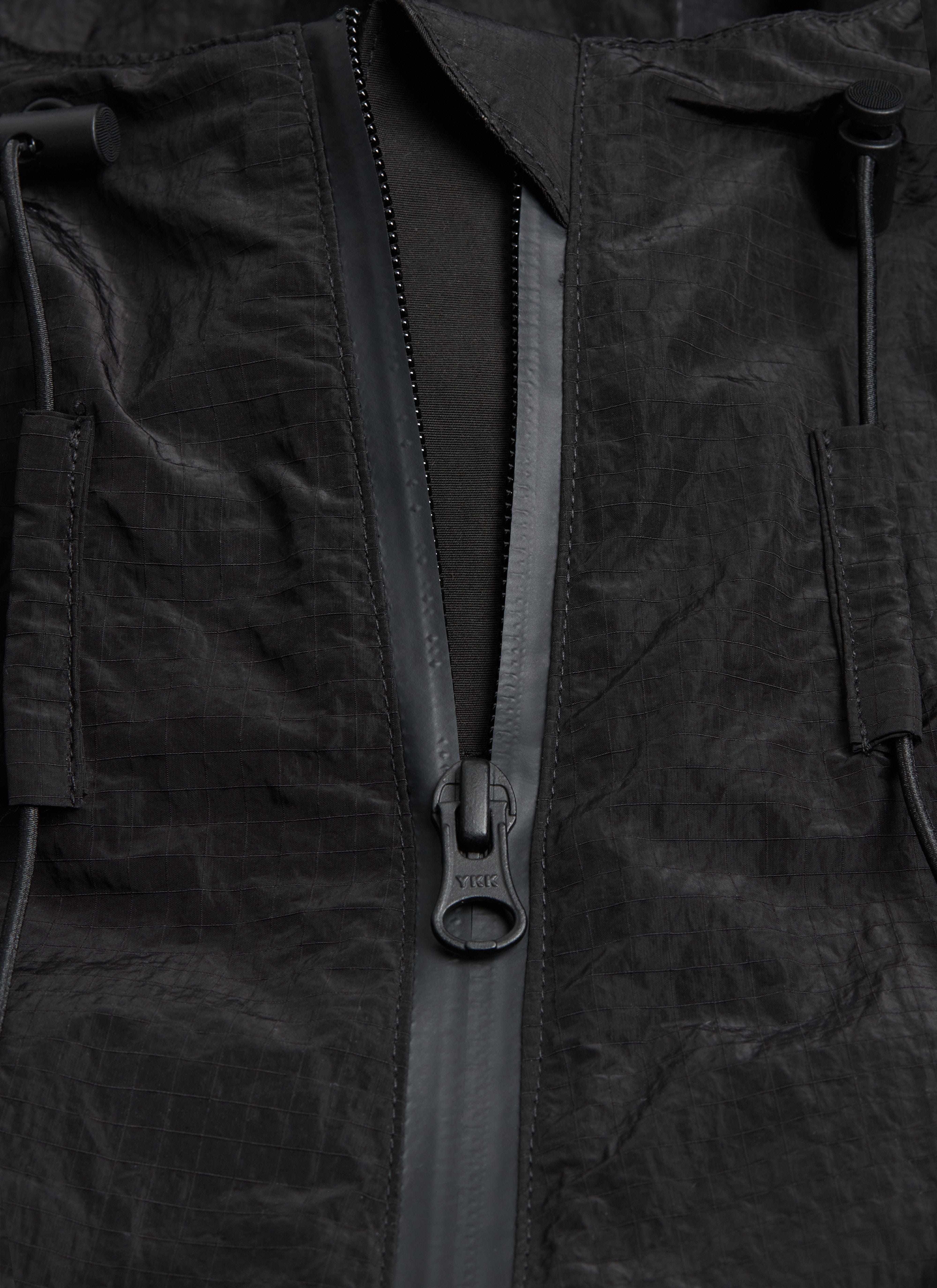 Detail shot of the Percival PCVL Zip Through Jacket in black, focusing on the water-resistant zip and ripstop material.