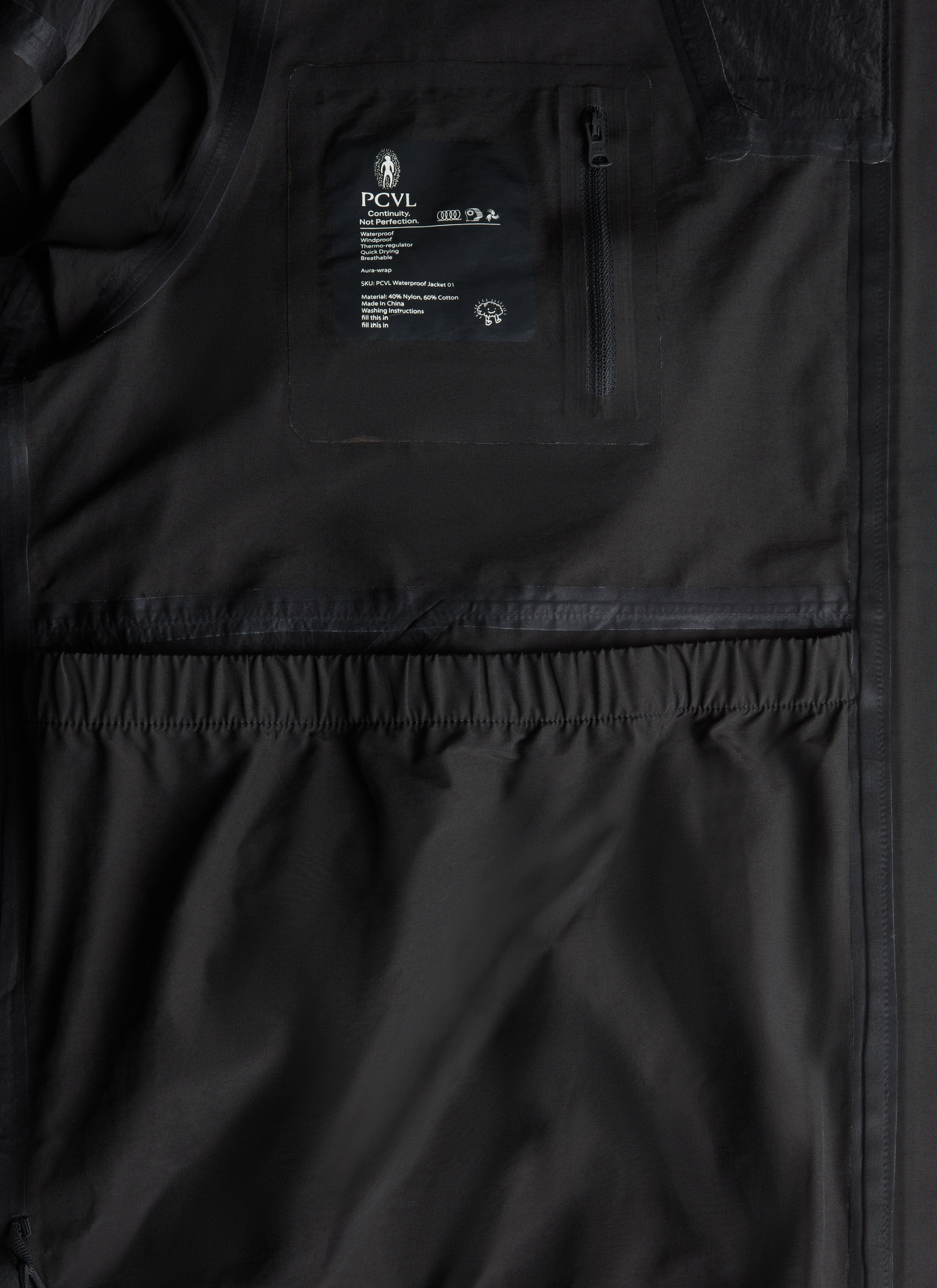 Close-up of the interior of the black PCVL Water Resistant Jacket from Percival, showing the technical label and taped seams.