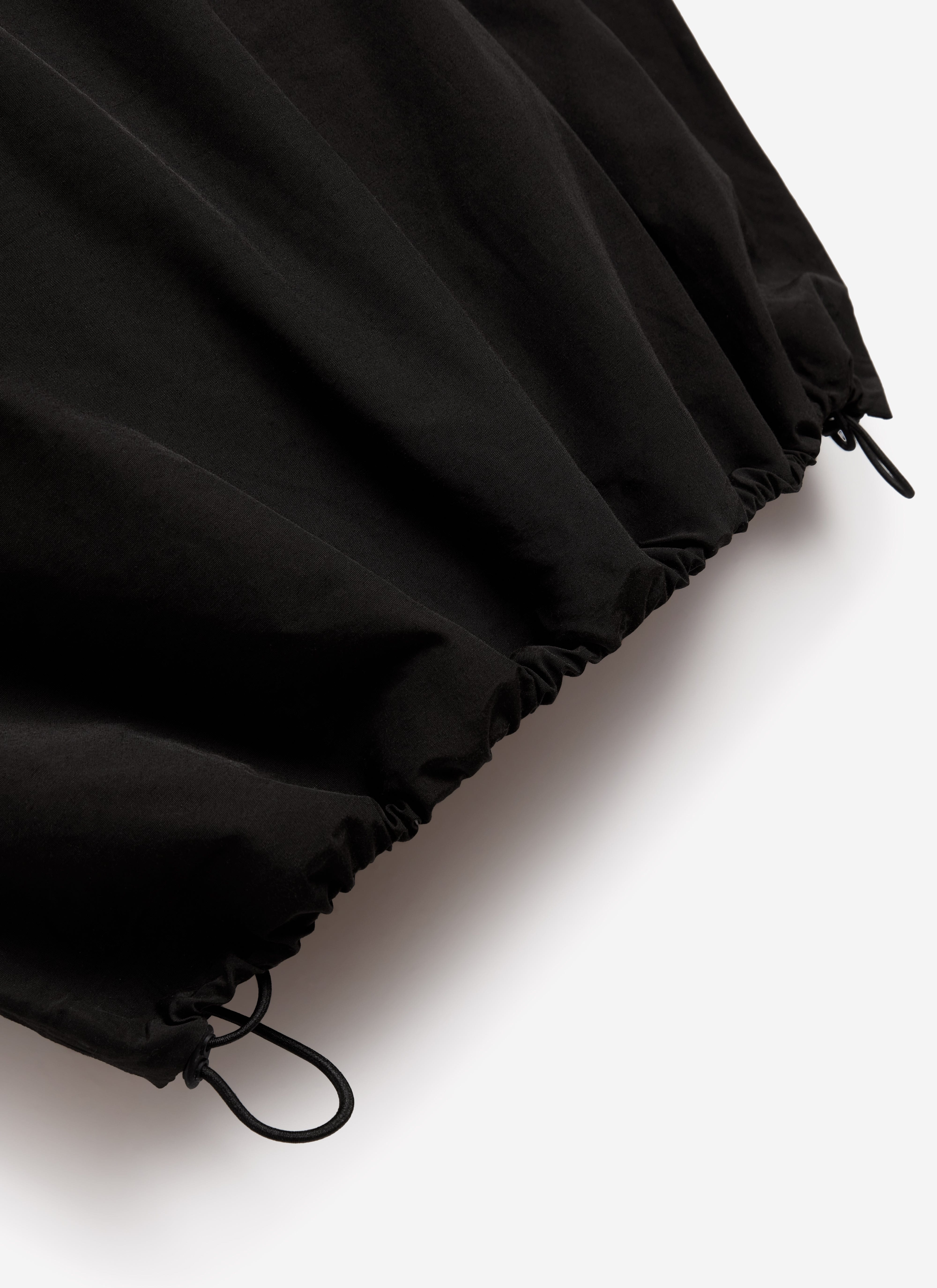 A close-up of the adjustable drawcord hem on the black PCVL Zip Through Water Resistant Jacket from Percival.