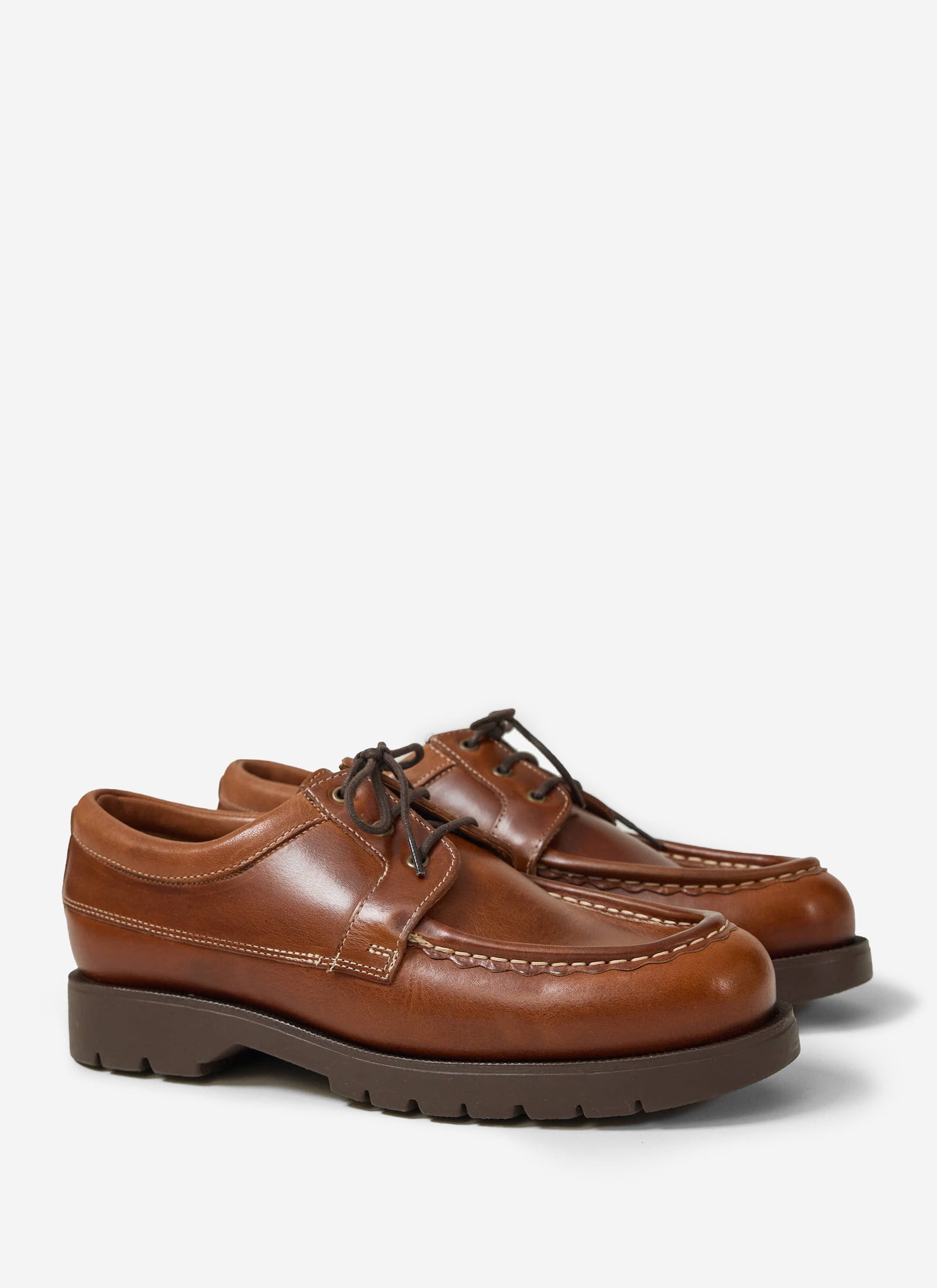 A studio shot of the Percival x Kleman Alfan TH shoes in cognac leather, featuring a moc-toe design and thick rubber sole.