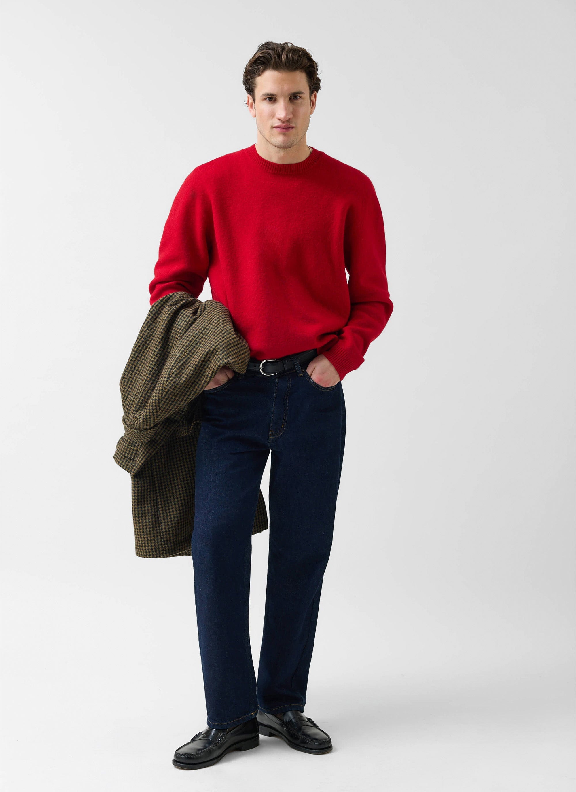 A model styles the red Percival Felted Merino Wool Jumper with dark jeans and loafers, holding a houndstooth jacket.