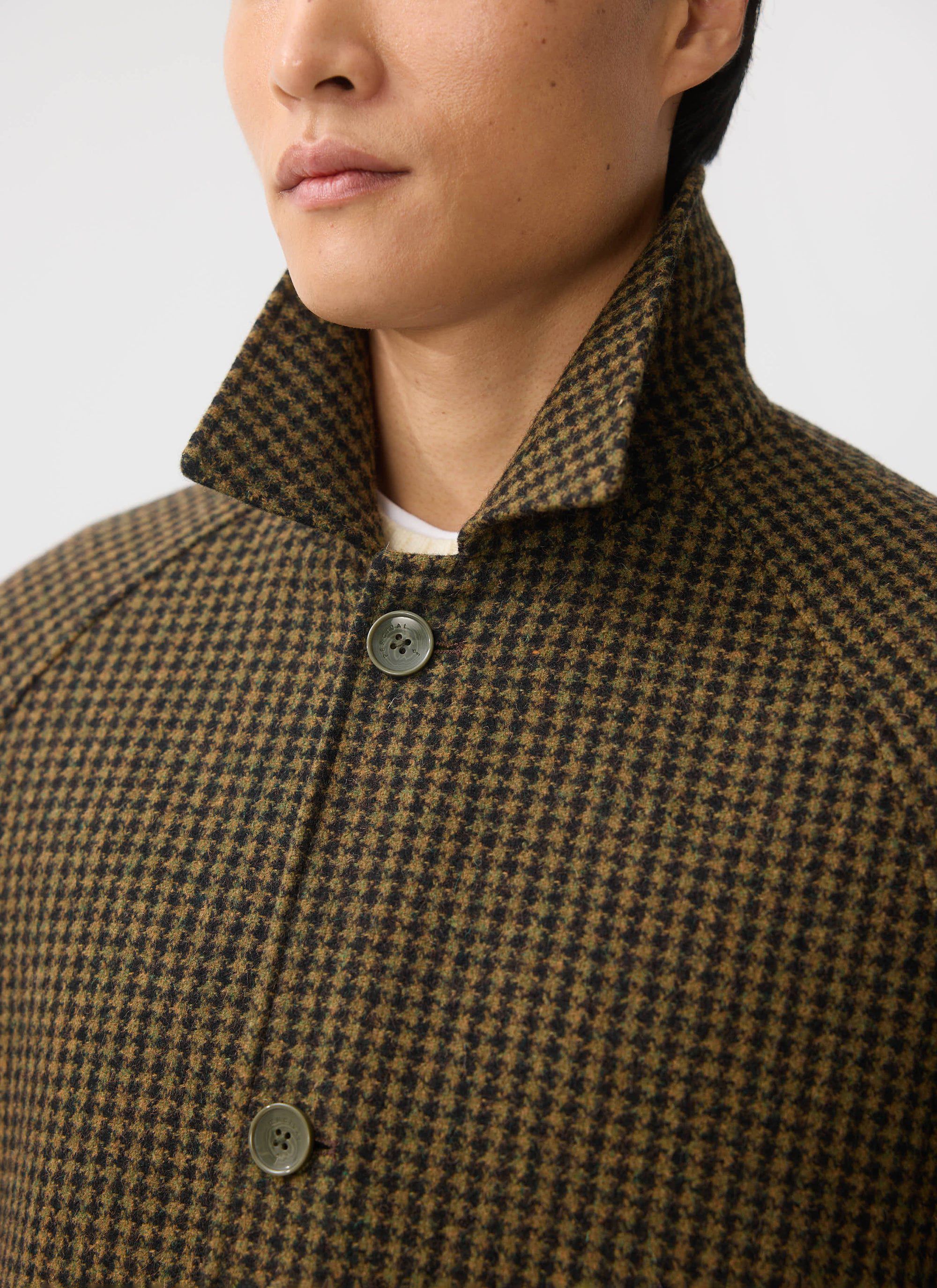 A close-up of a model wearing the brown houndstooth Percival Dickens Car Coat, focusing on the collar and button detail.