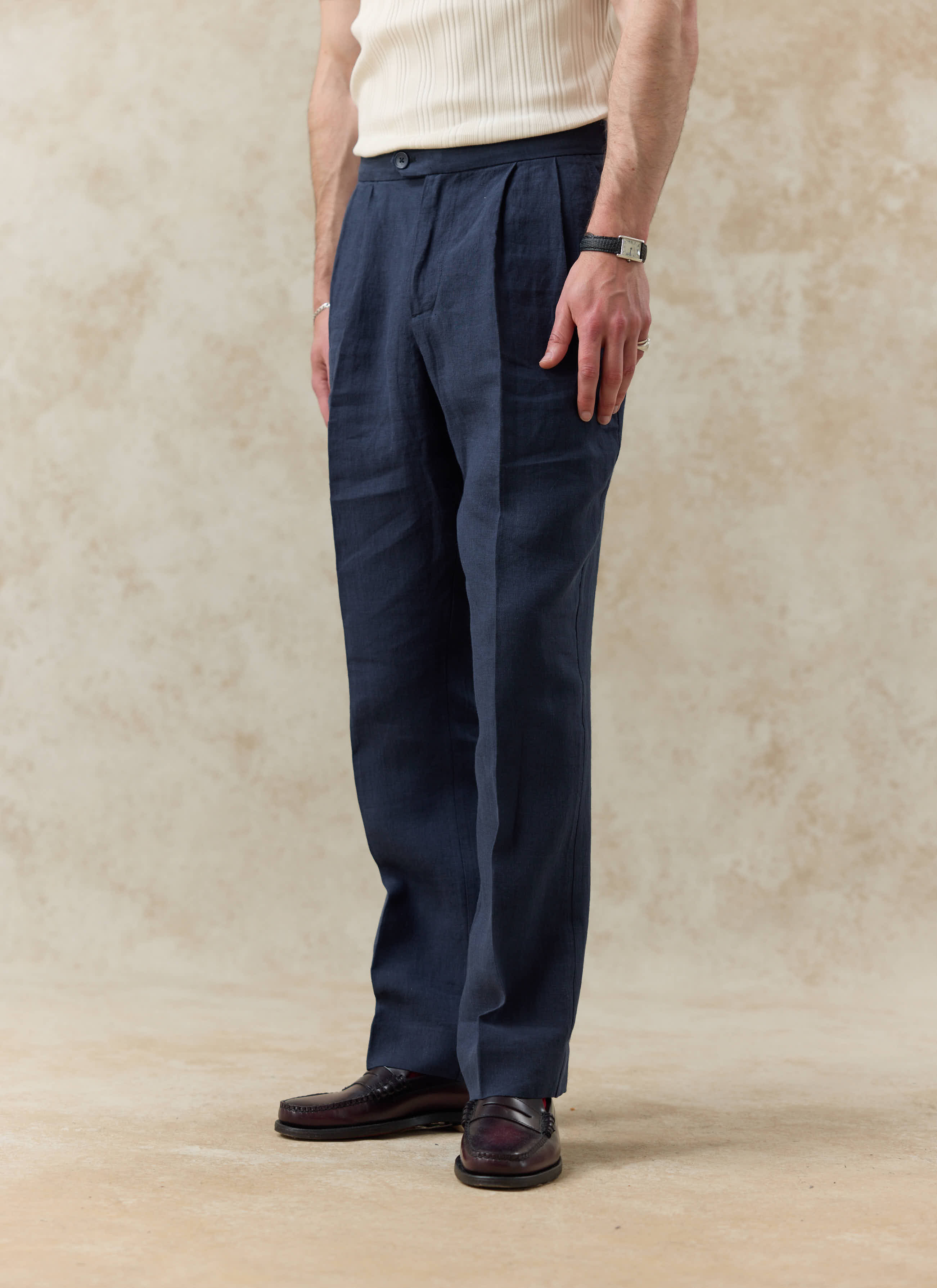 Navy blue linen pleated tailored trousers by Percival, featuring a relaxed fit and smart double pleat detail.
