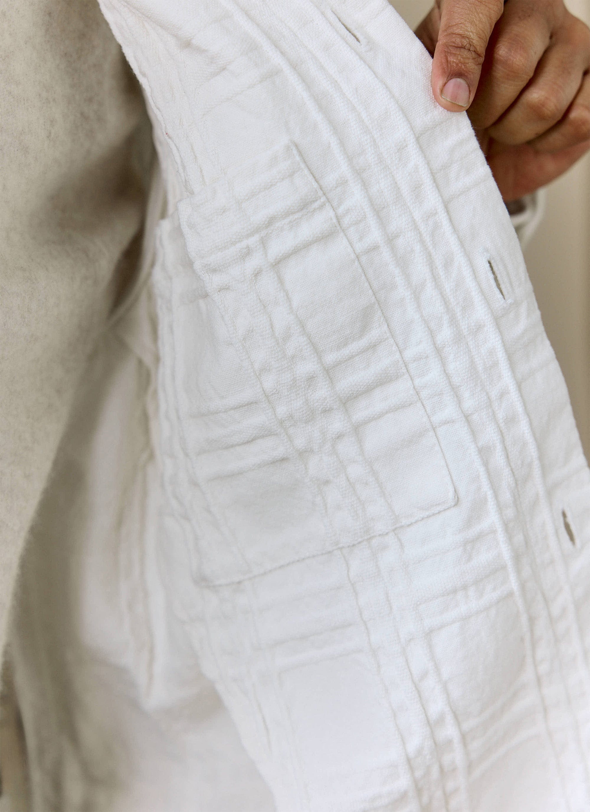 A close-up view of the textured interior and internal pocket of the ecru Canyon Overshirt from Percival.