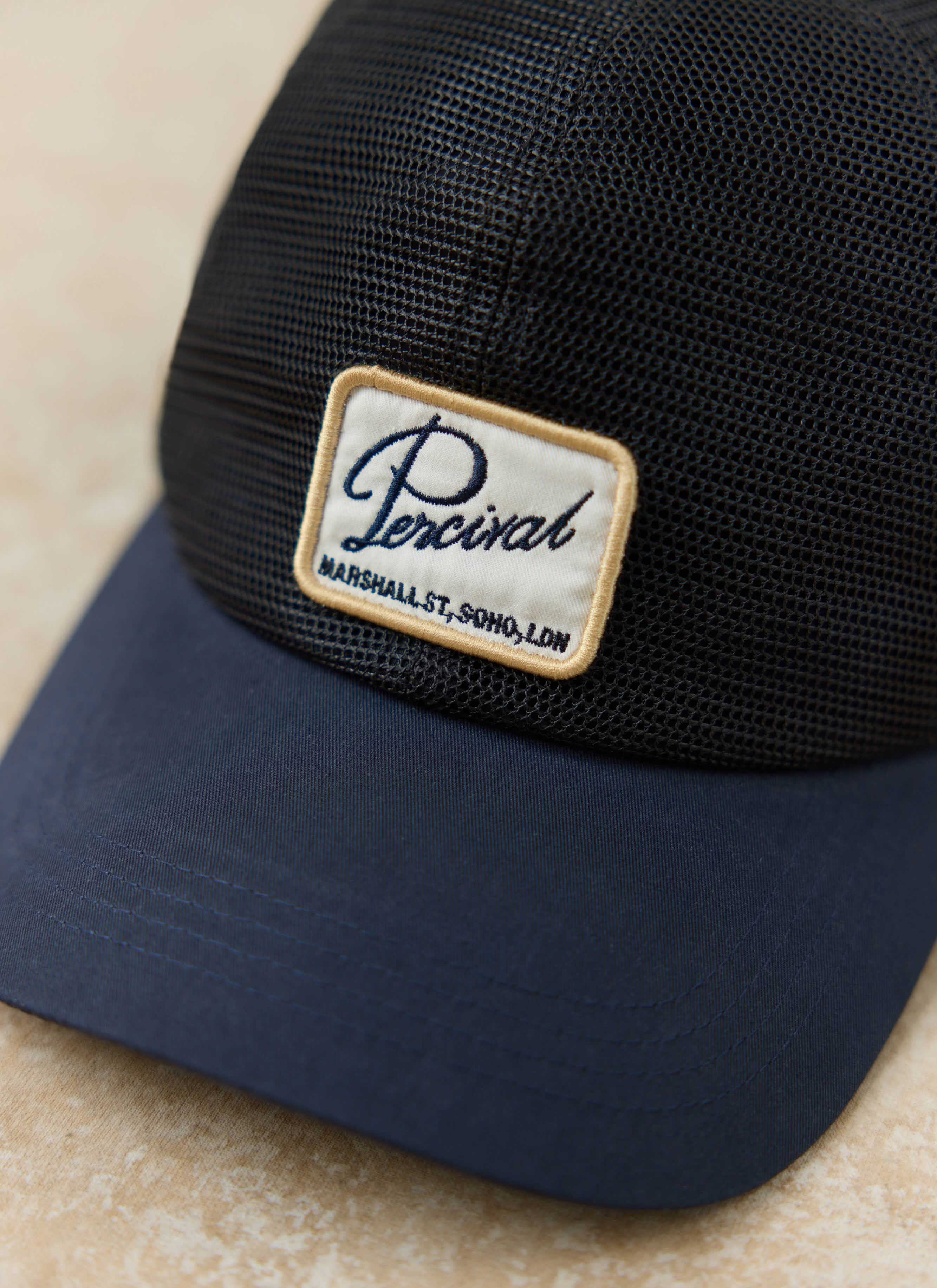 Navy Damien Mesh Trucker Cap by Percival, featuring a breathable mesh crown and an embroidered logo front patch.
