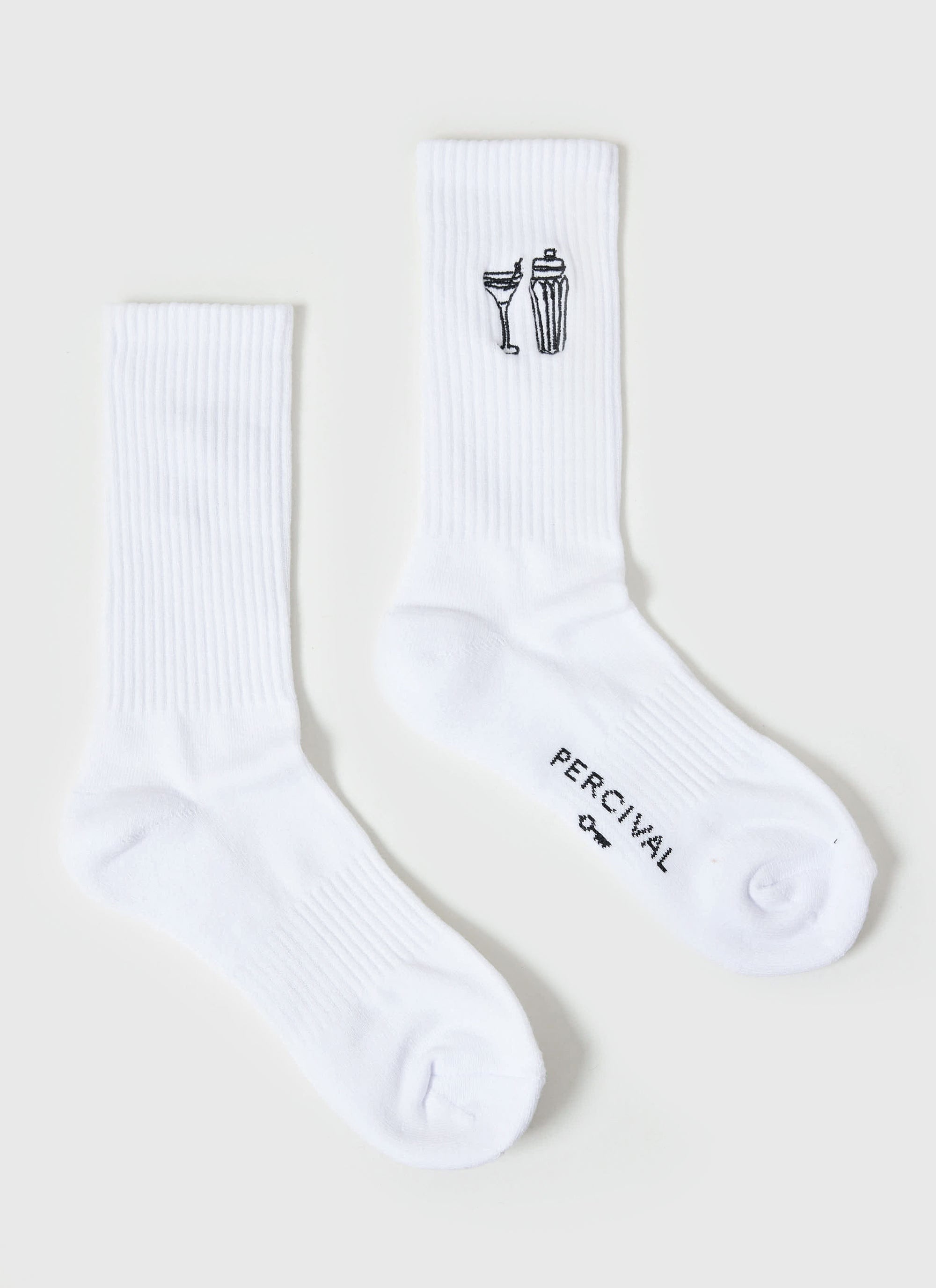 The Percival Mixologist Embroidered Socks in white, laid flat to showcase the cocktail glass and shaker embroidery.