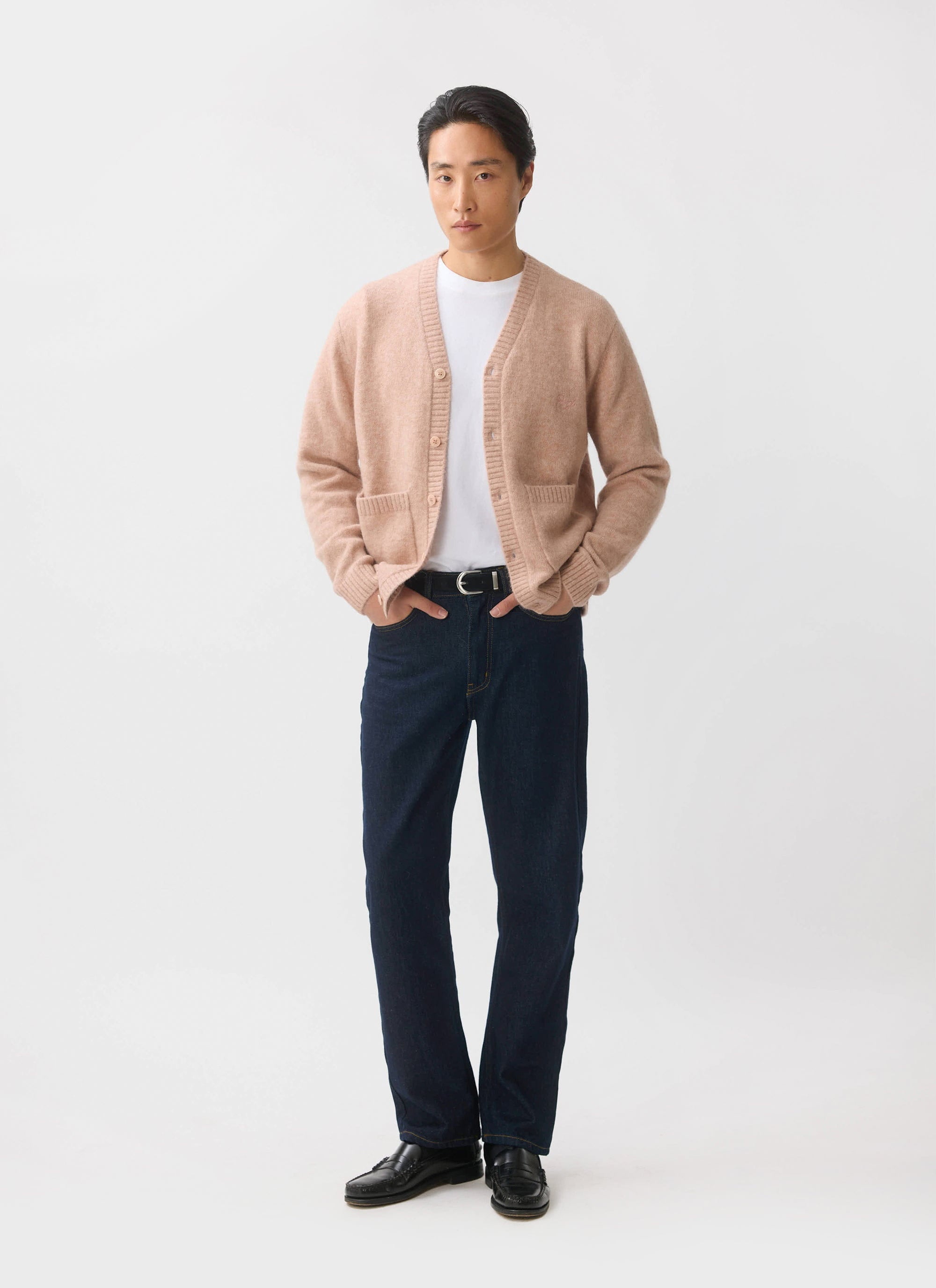 A male model wears the Percival White Glove Cardigan in pink mohair with a white t-shirt and dark blue jeans.
