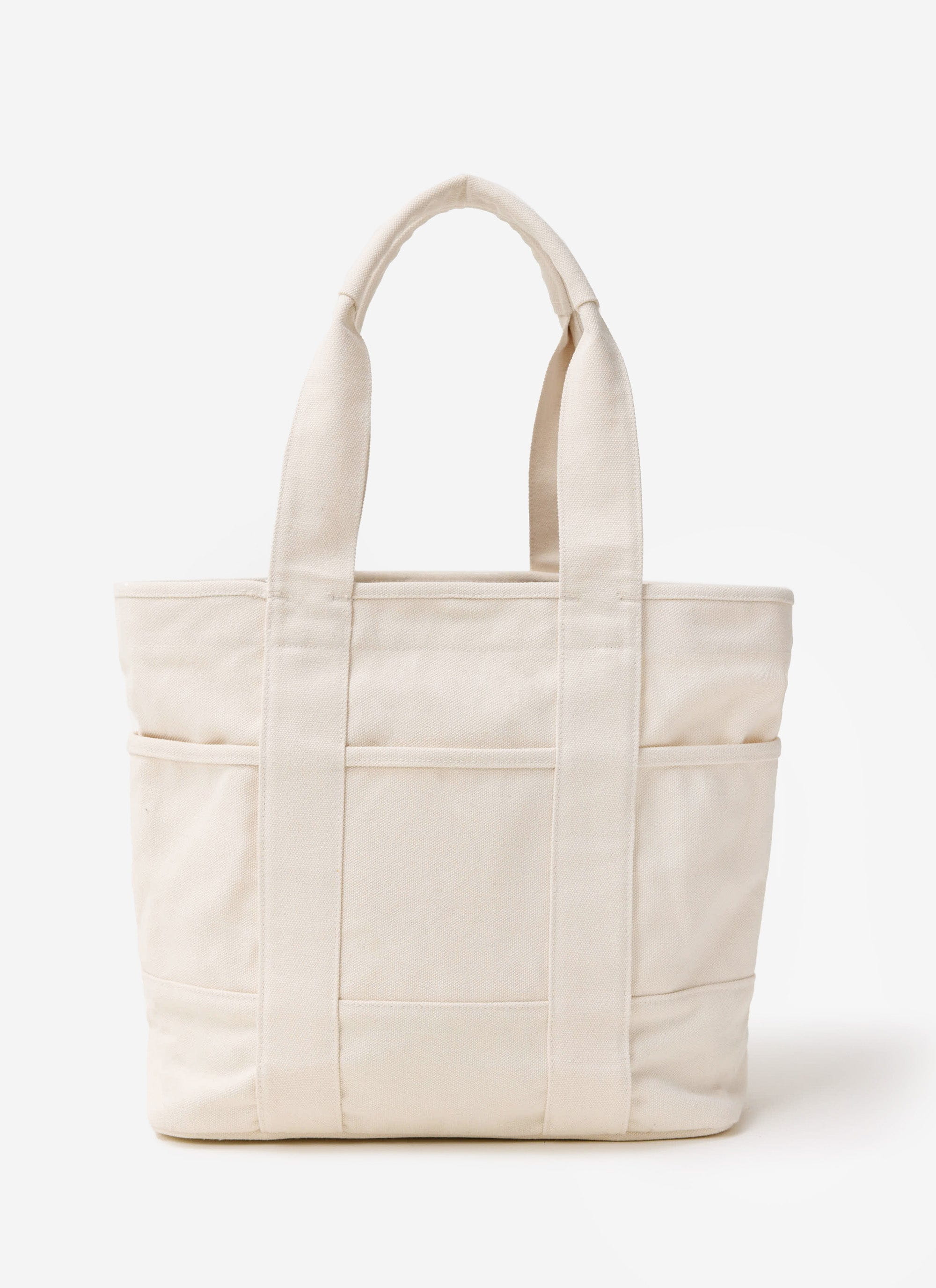 A studio shot of the Percival tote bag in ecru, made from heavy-weight cotton canvas and featuring external pockets.