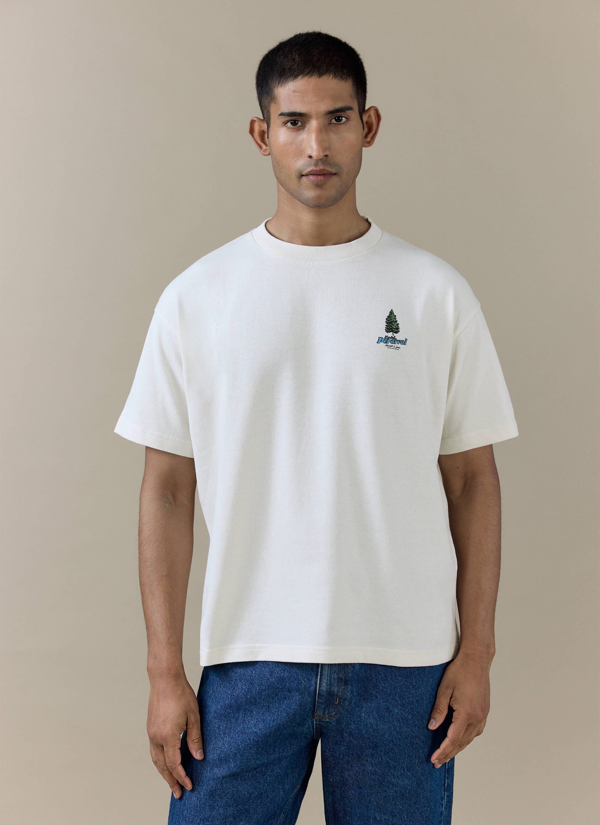Percival Arnold Oversized T Shirt in cream organic cotton with a pine tree chest graphic, worn by a model.