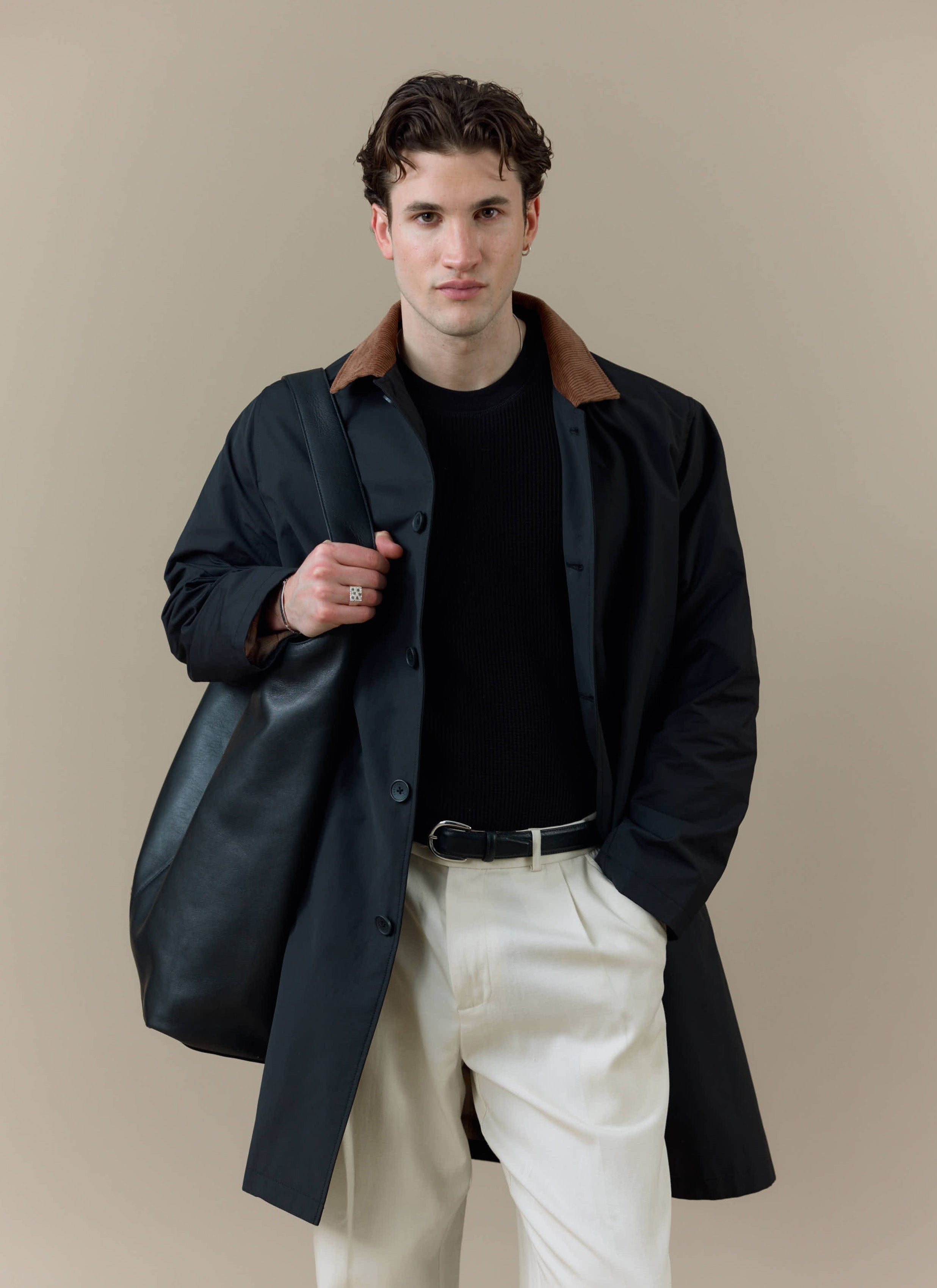 A model wearing the black Percival Cord Collar Relaxed Trench Coat, featuring a contrast brown corduroy collar.