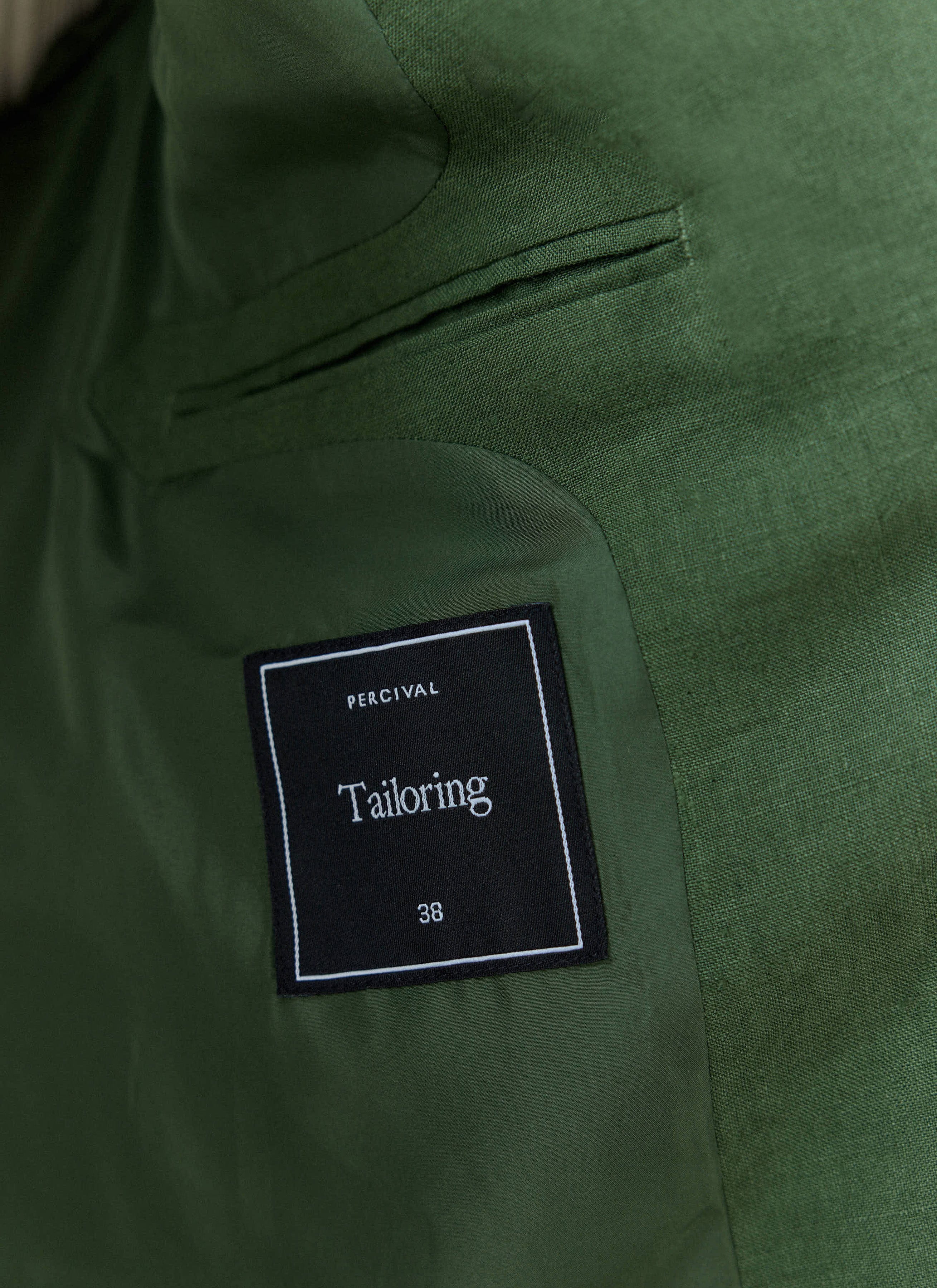 A close-up of the internal tailoring label and pocket inside the Percival forest green linen Slim Fit Classic Blazer.