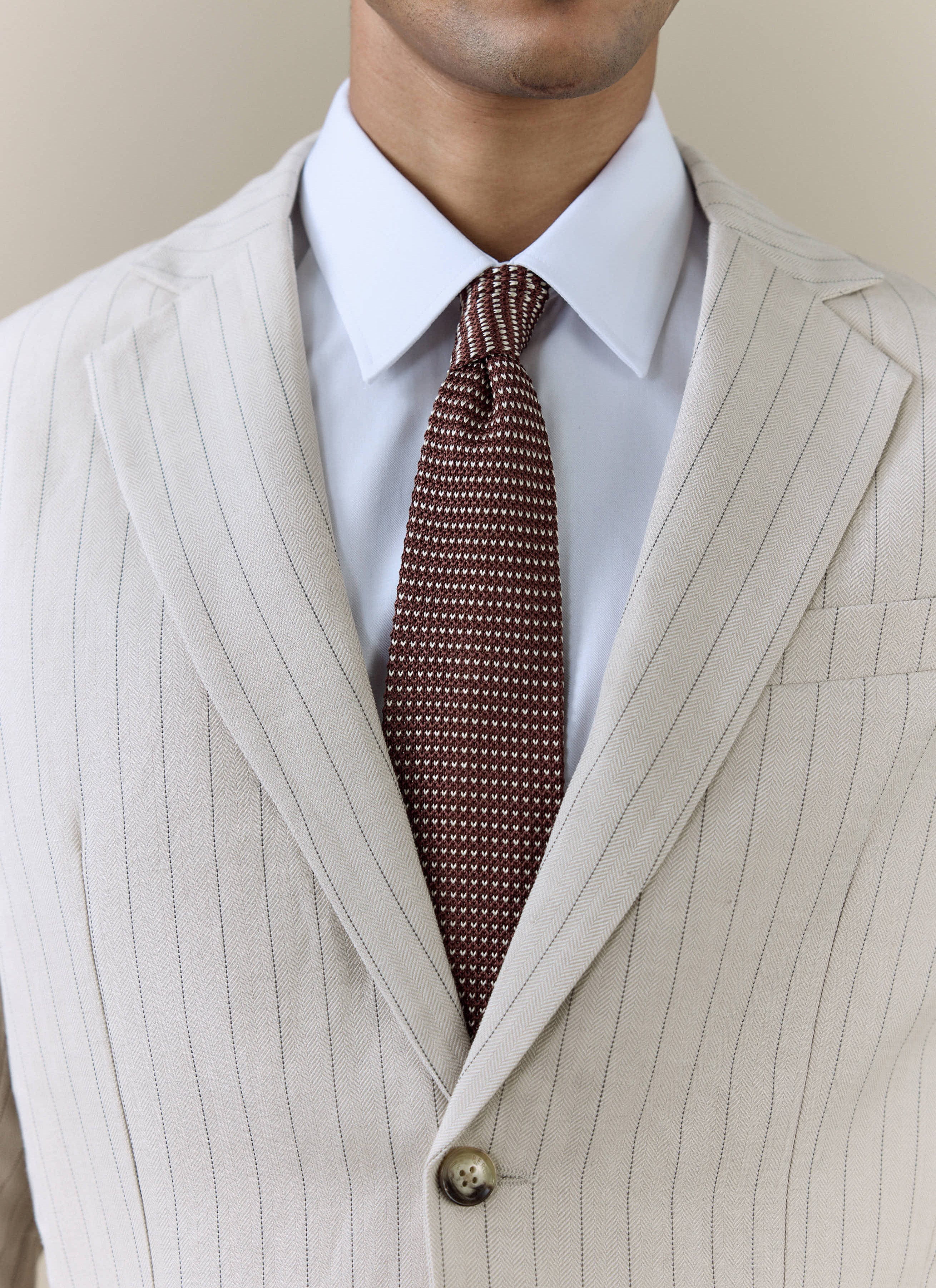 Percival Birdseye Silk Tie in espresso brown, styled with a white shirt and a cream pinstripe suit.