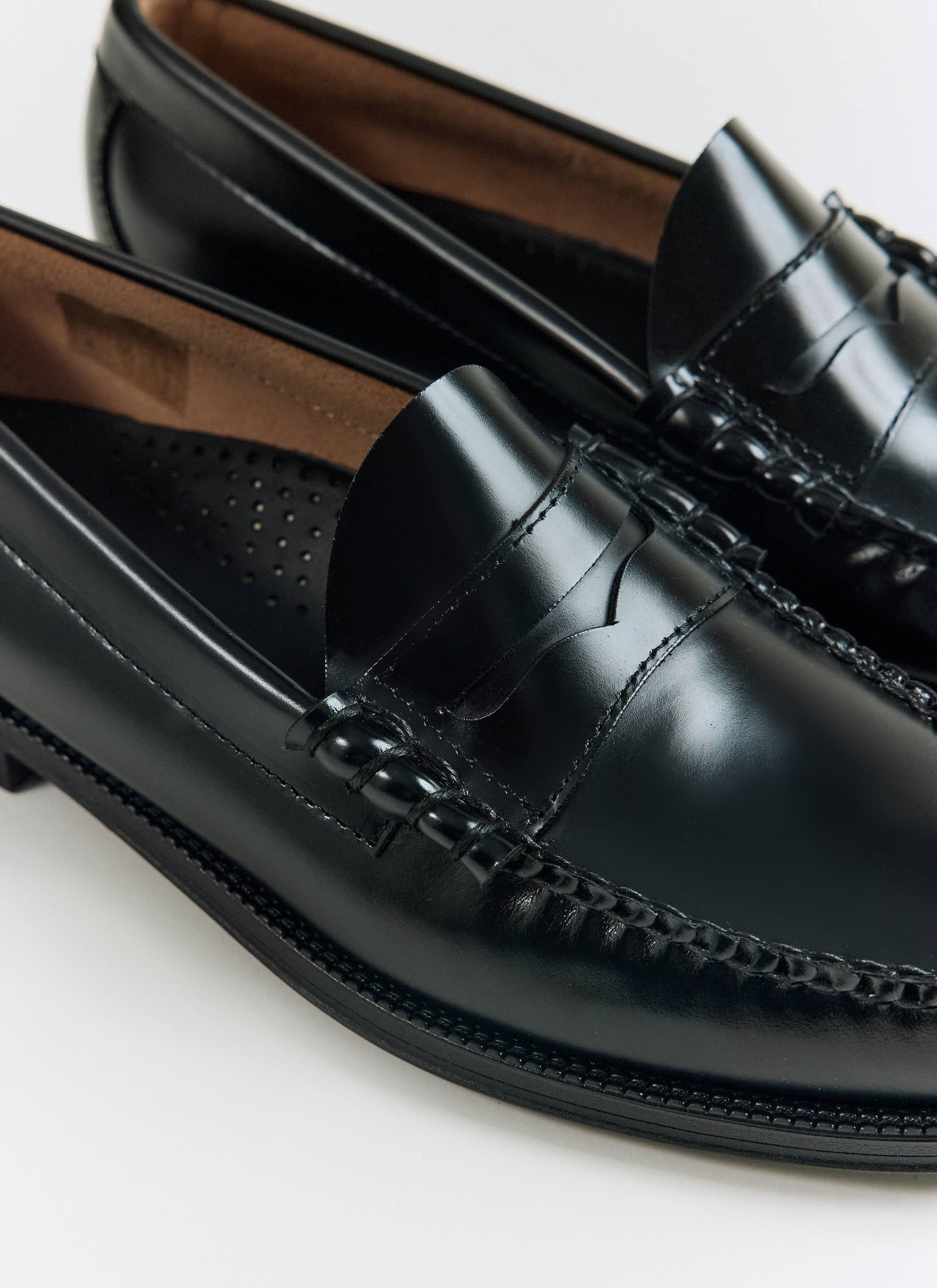 Close-up of the black G.H.Bass Weejun II Larson Moc Penny loafers, showing hand-stitched leather details at Percival.