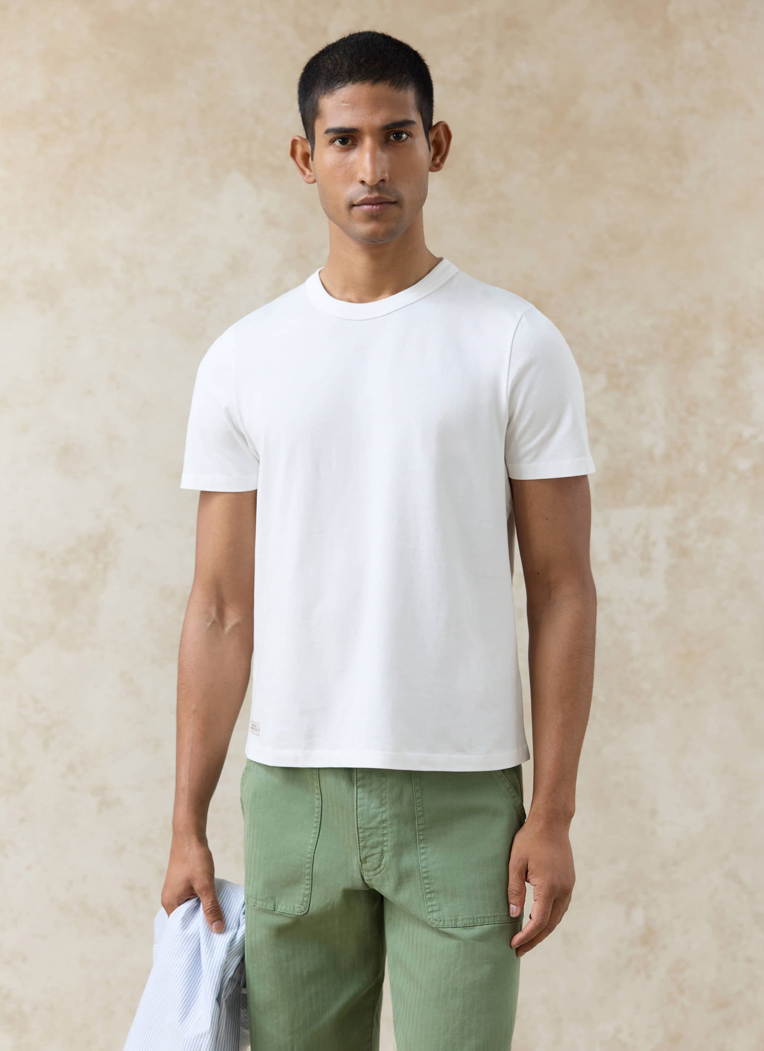 Percival Austin Slub slim fit T-shirt in off white organic cotton, styled on a model with olive green trousers.