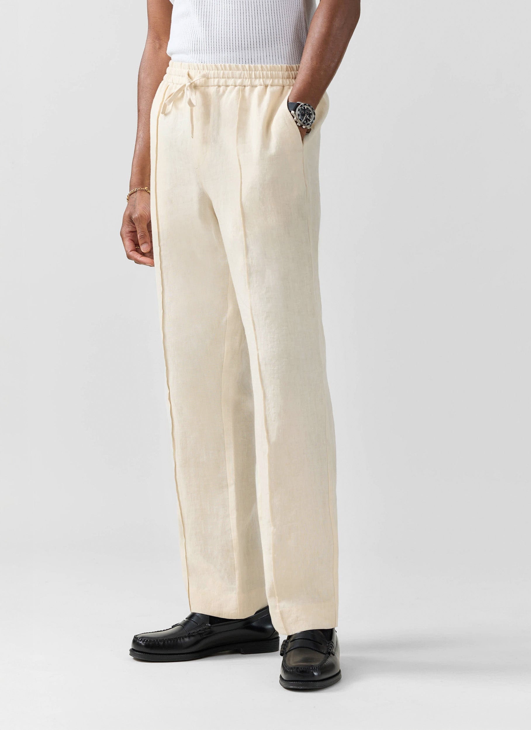 A close-up of a model wearing the Percival Lorena Wide Leg Trousers in cream linen, with a relaxed fit and drawstring waist.
