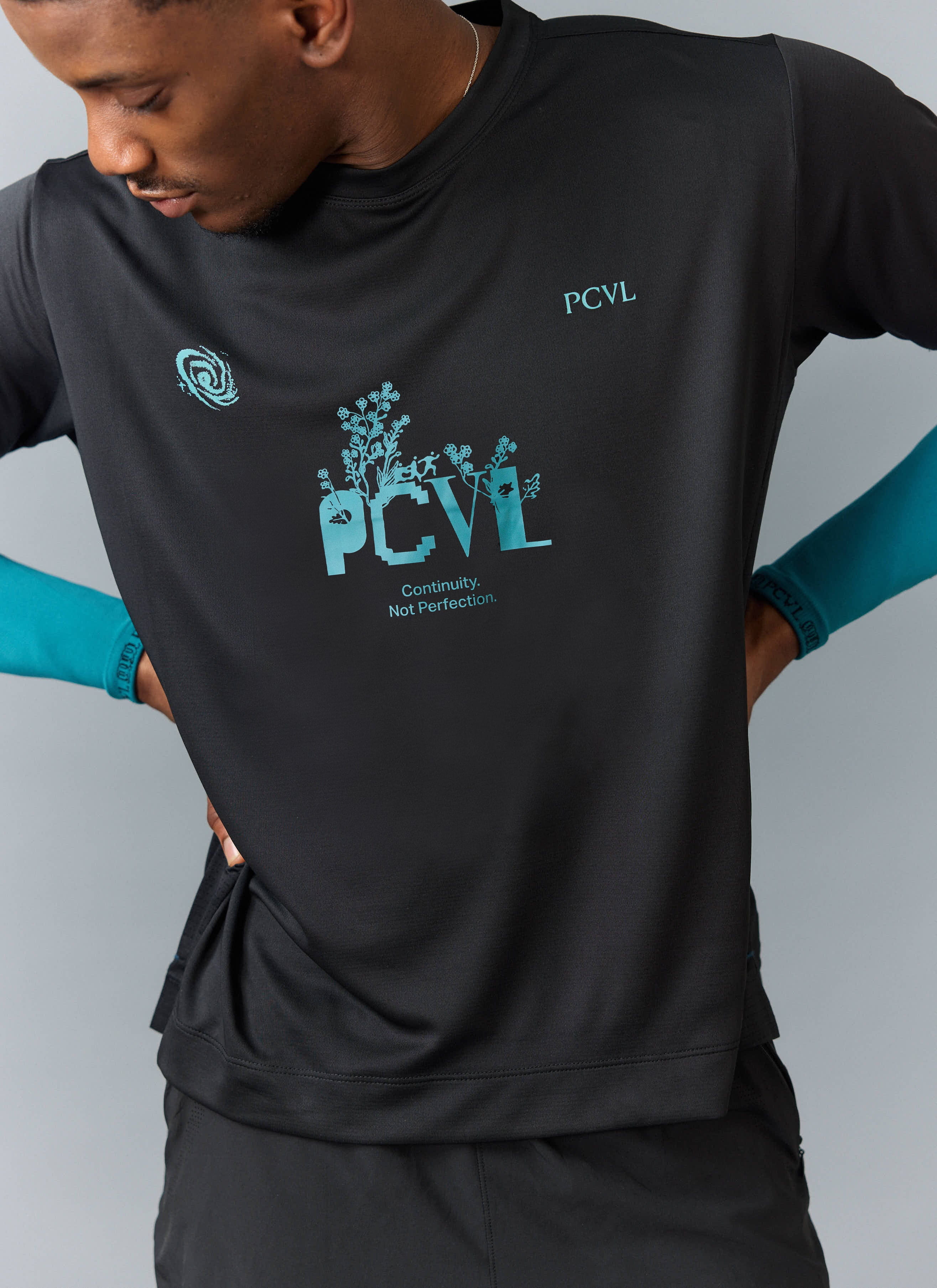 A close-up of the Percival PCVL Graphic Printed Performance Top in black, showing the detailed teal graphic on the chest.