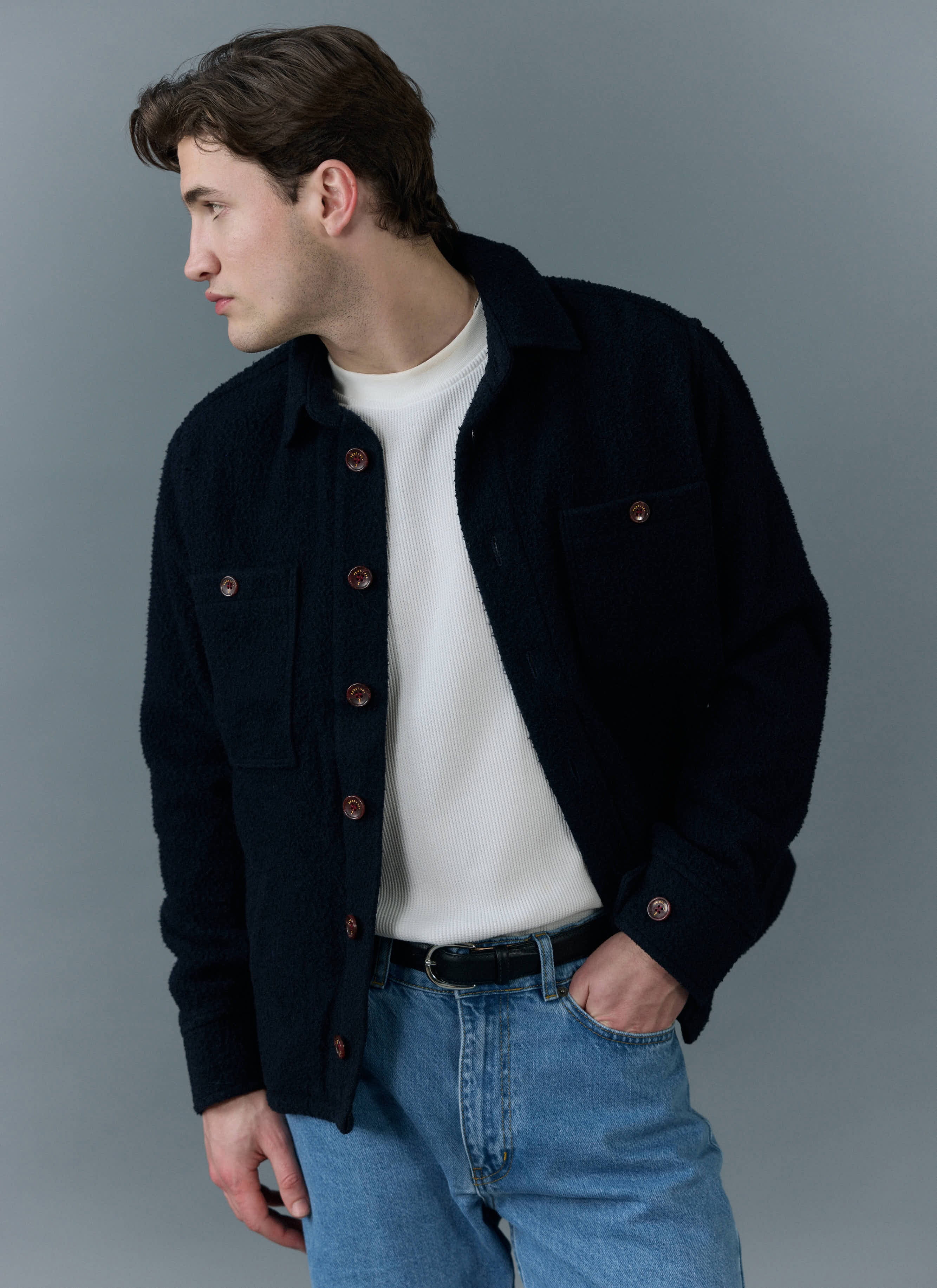 A model wears the Percival Blanket Overshirt in navy Casentino wool, styled with a white top and jeans.